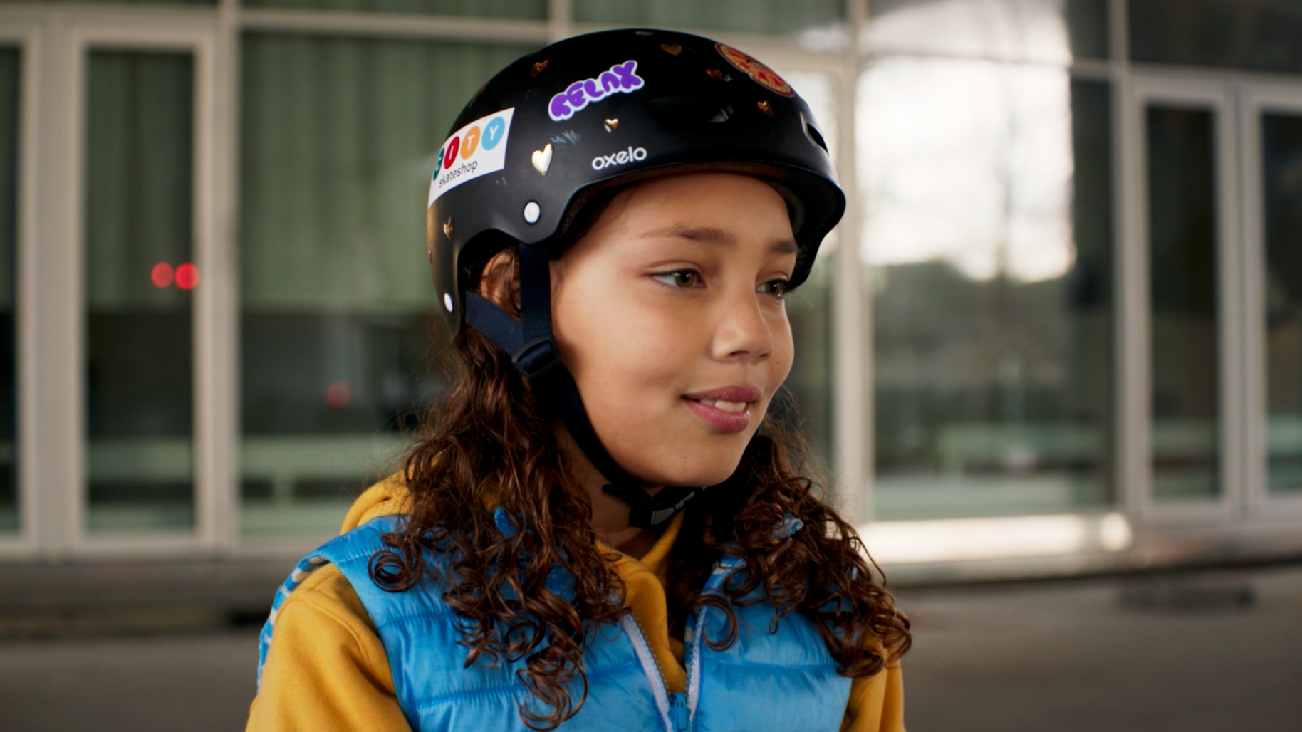 Jeune fille avec casque de protection, vêtements de sport, cheveux bouclés, en extérieur