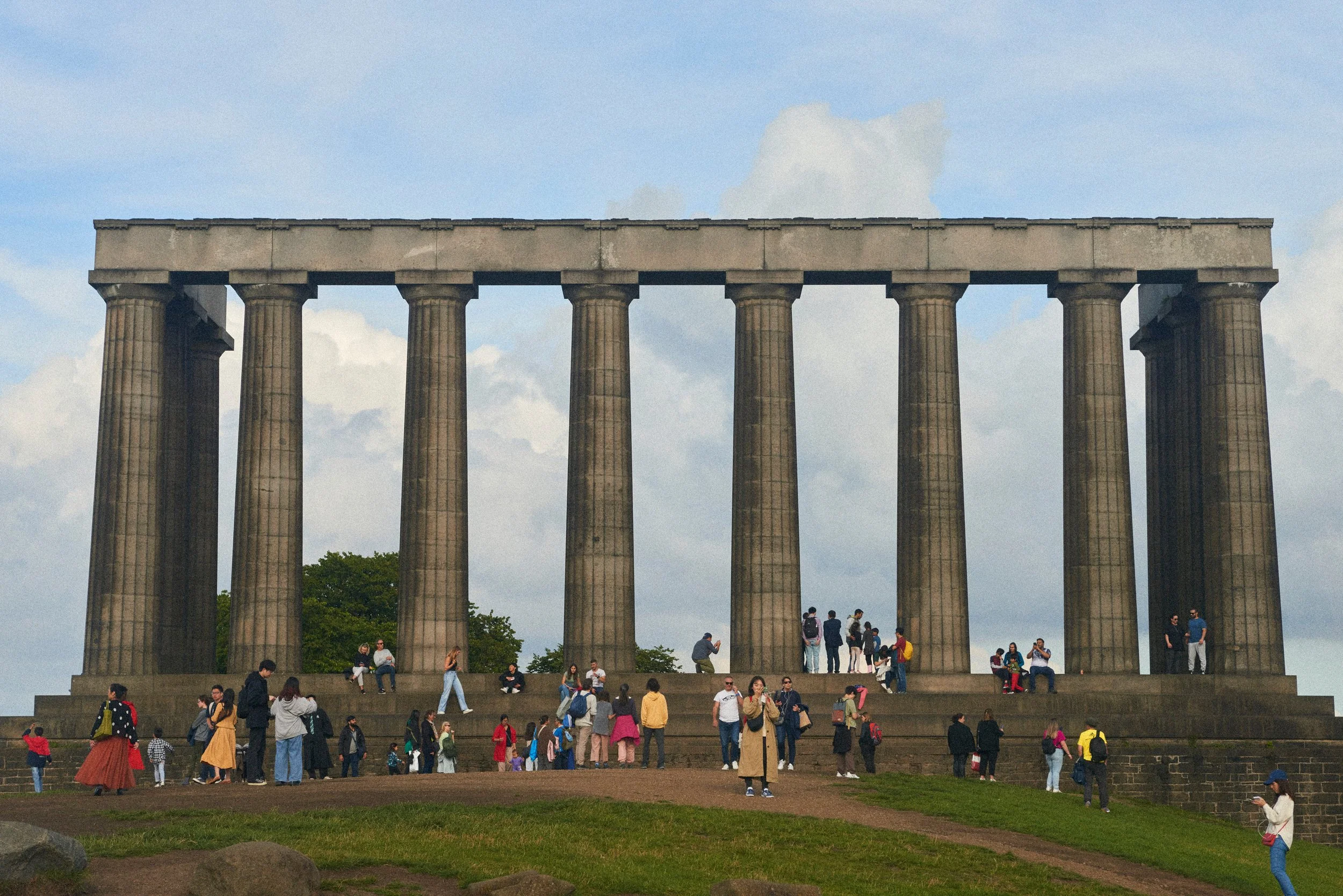 Le site historique du mémorial de l'abolition en Écosse avec une grande structure en pierre ressemblant à un temple, entourée de nombreux visiteurs en journée