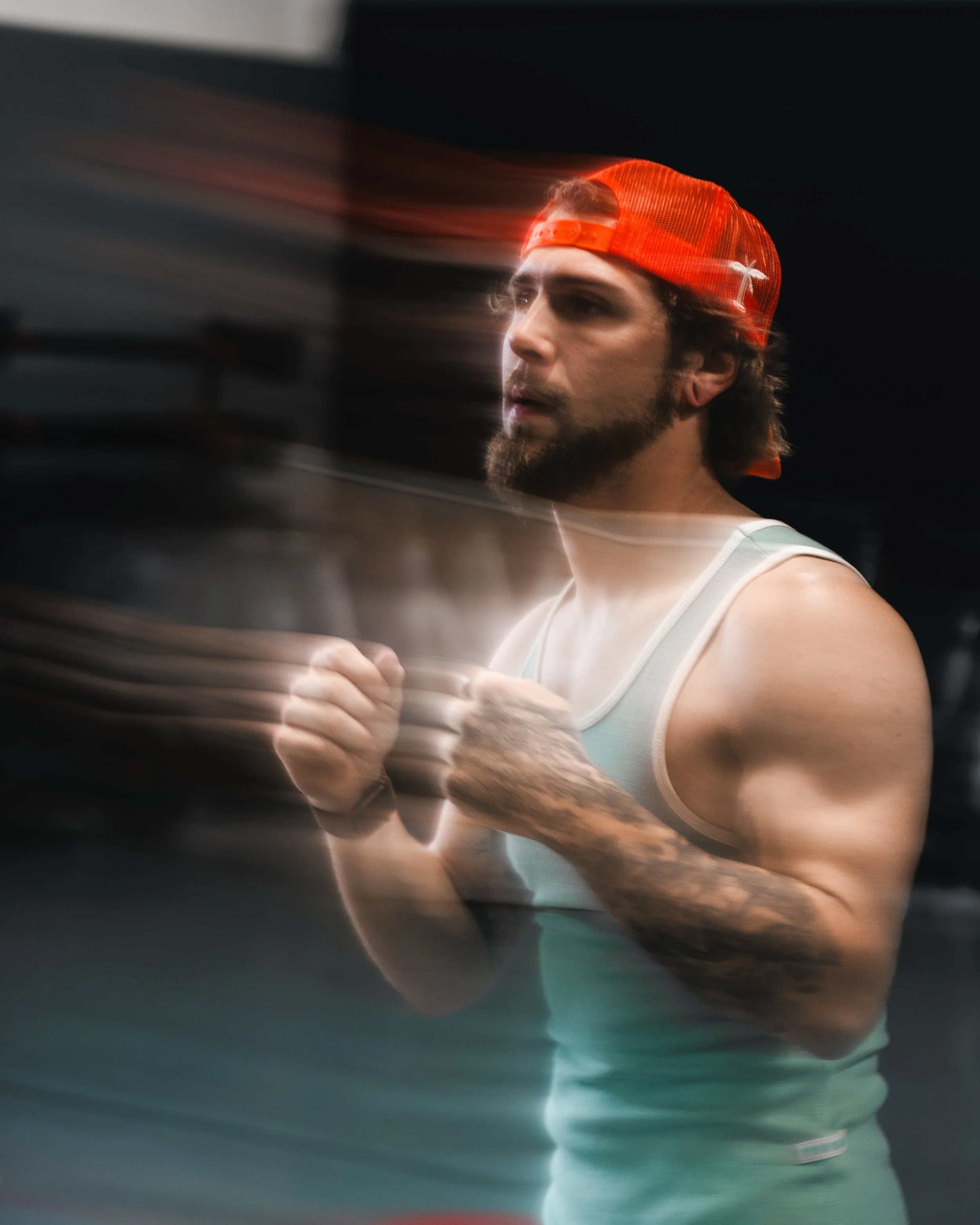 A man with a beard wearing a red baseball cap, looking to the side, appears to be in motion or blurred in the image.