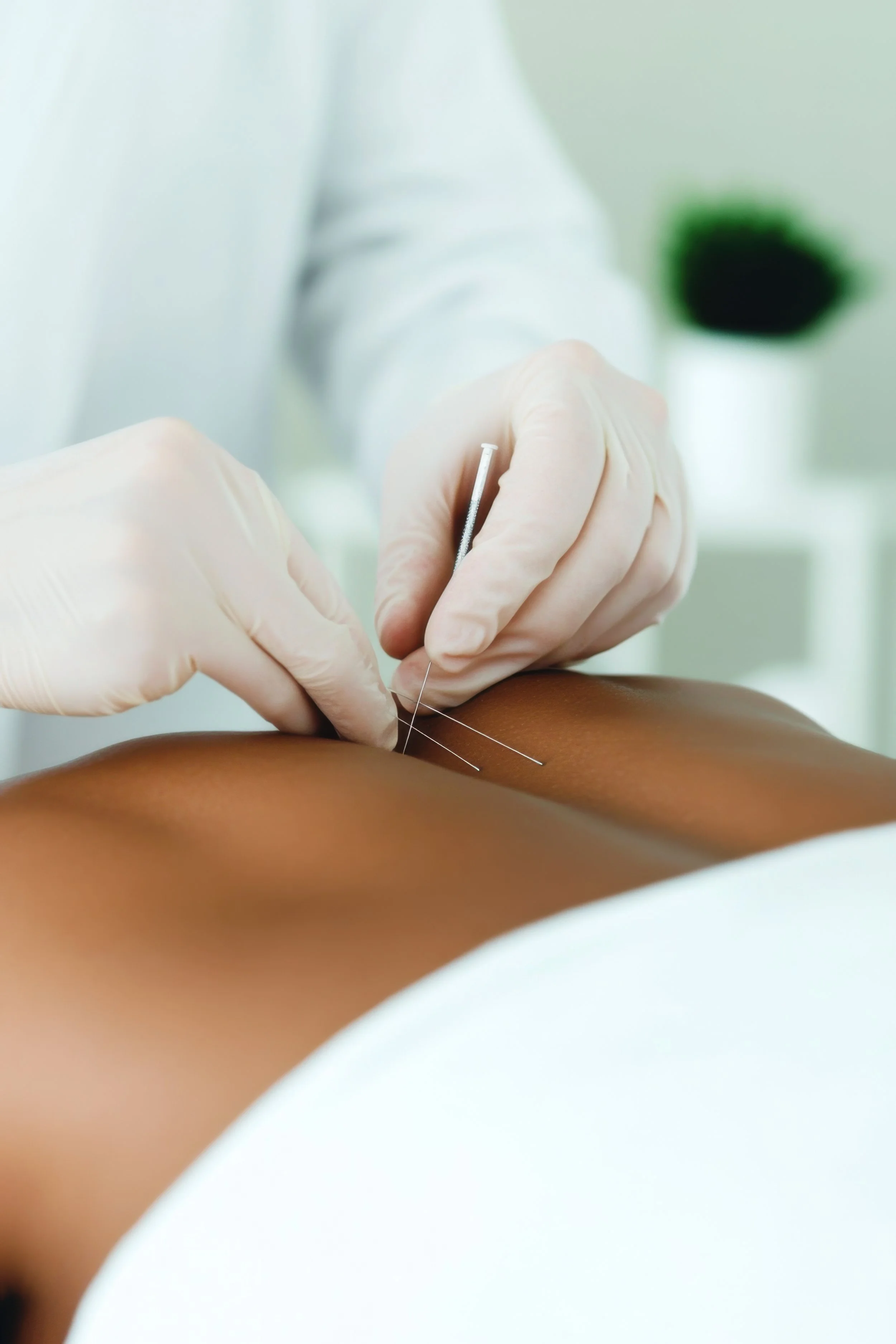 A healthcare professional wearing gloves administering an injection to a person's arm.