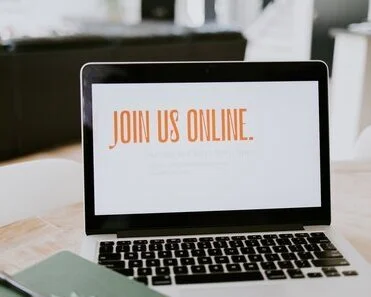 Laptop showing a screen with the text "Join us online" in orange letters.