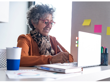 Latina woman working at a computer representing culturally responsive therapy in Spanish