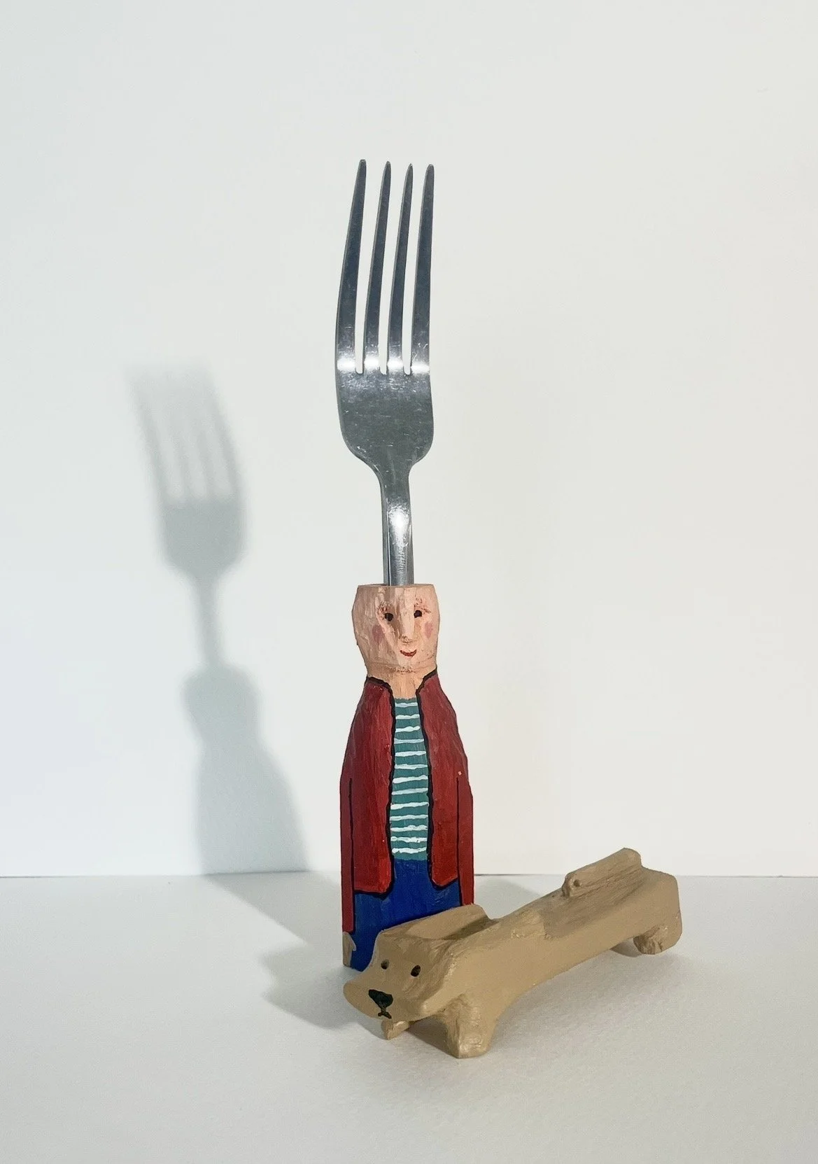 "A Fork and His Dog" wood carving and acrylic, 2026