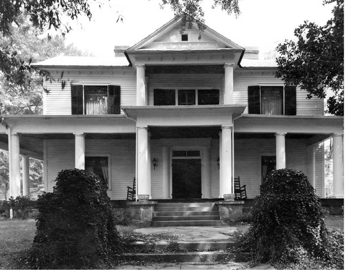 Historic photograph of The Veranda Historic Inn in Senoia, Georgia, showing the original two-story home and front porch.