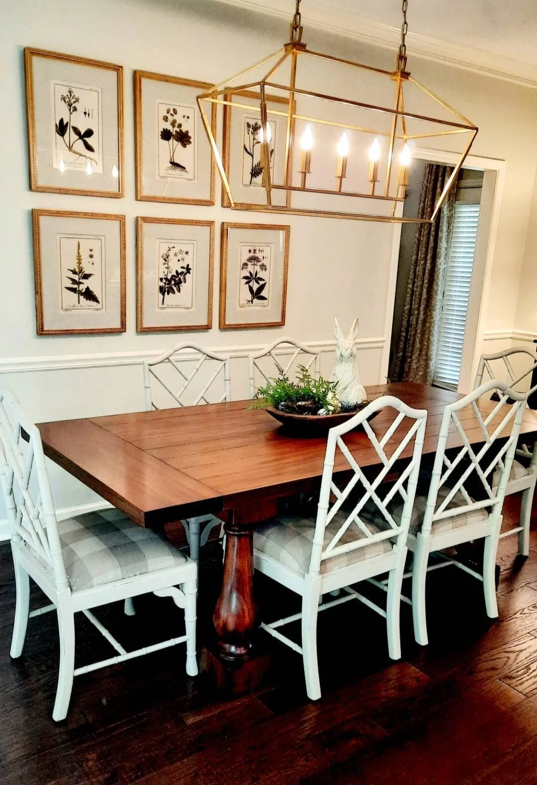 Breakfast nook with a dark wood table, white Chippendale chairs, and a gallery wall of framed bird prints designed by Bonnie Boyette Designs