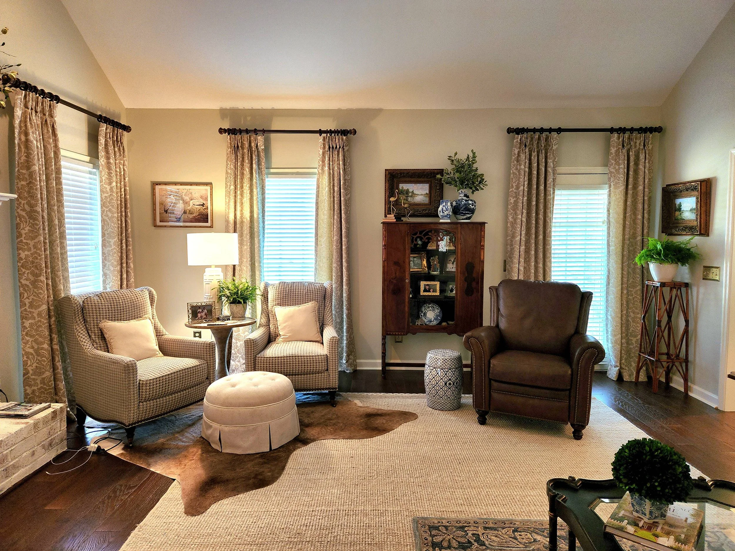 Family room with upholstered armchairs, a leather recliner, patterned area rug, and built-in bookshelves designed by Bonnie Boyette Designs