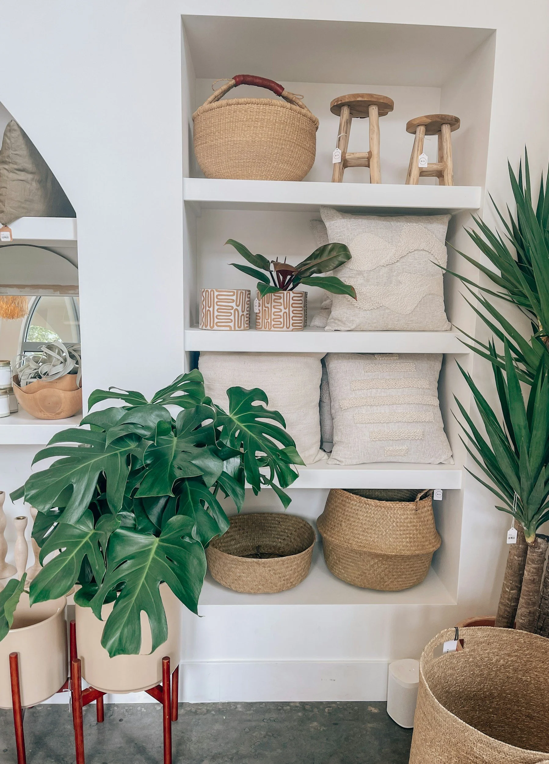 Shelves with woven baskets, cushions and plants