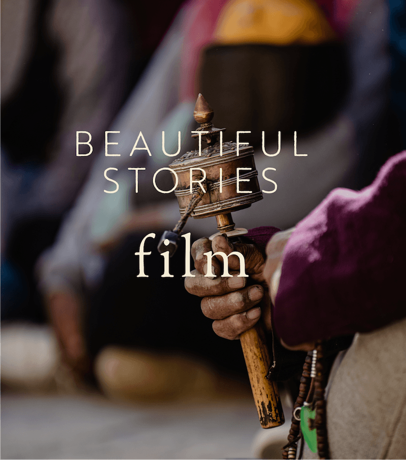 Close-up of a person's hand holding a traditional wooden hammer or mallet, with the words 'Beautiful Stories film' overlayed on the image.