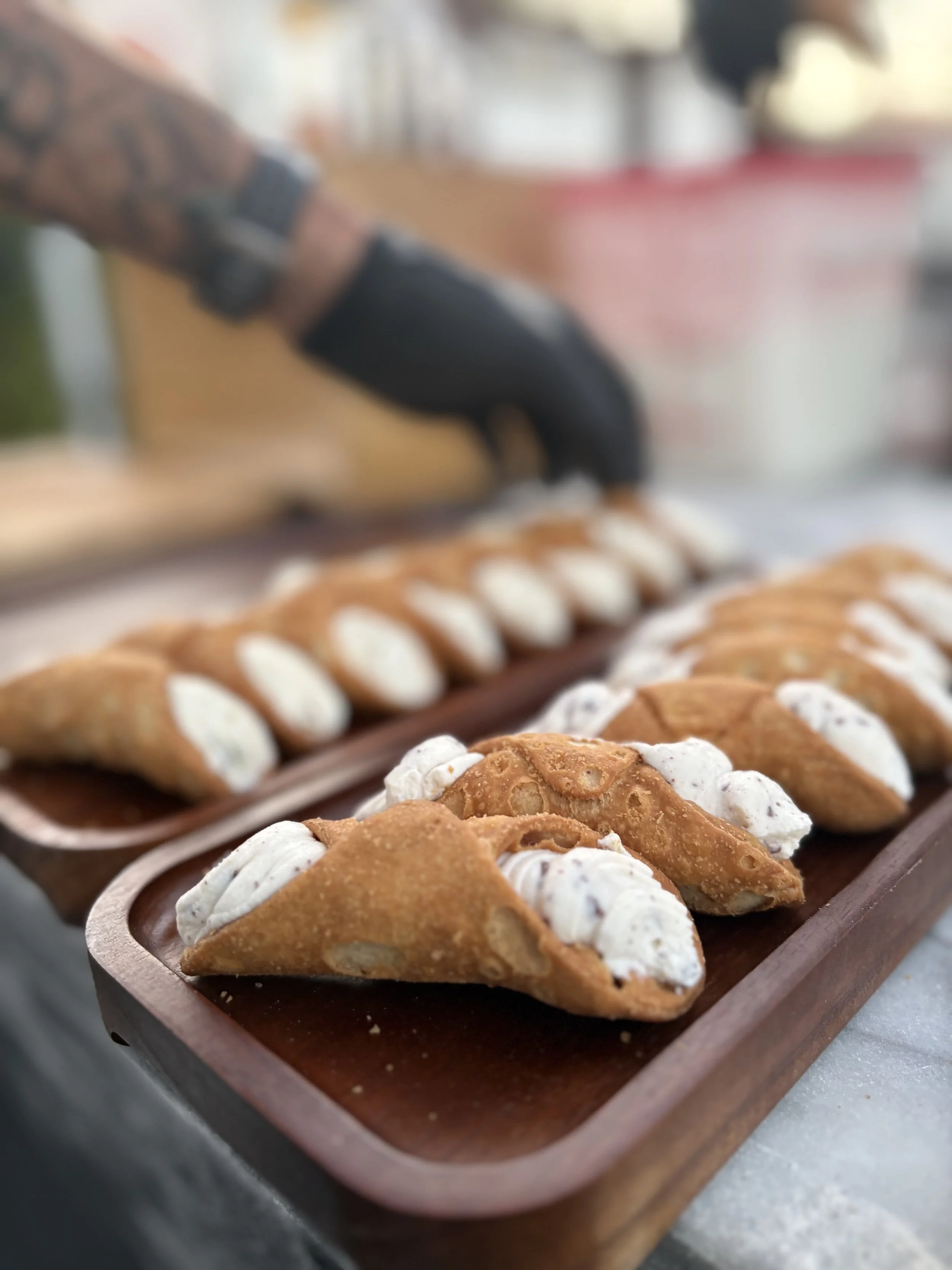 Close-up of traditional Mexican dessert, buñuelos, on a wooden platter, topped with powdered sugar and syrup.