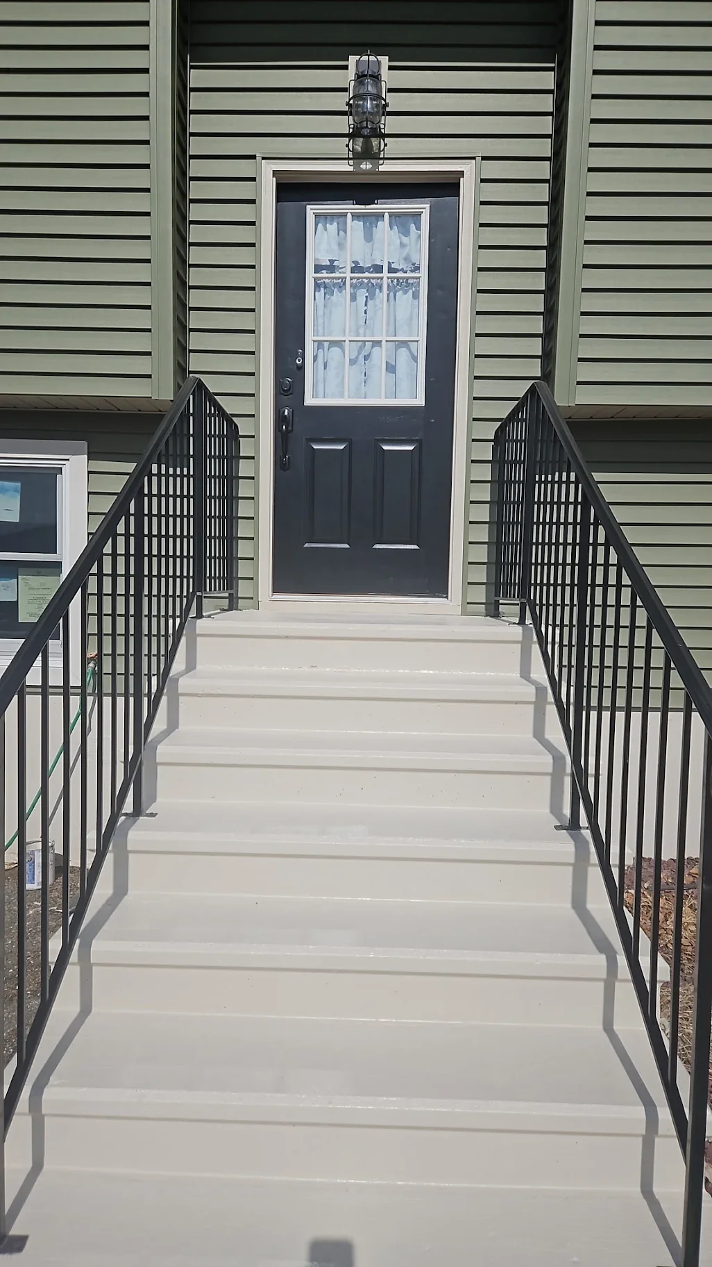 With what was left over of the black paint, we repainted the railings of her stairs. Some of the paint on her railings was peeling, so we chipped away at it until it was as smooth as possible, then painted.