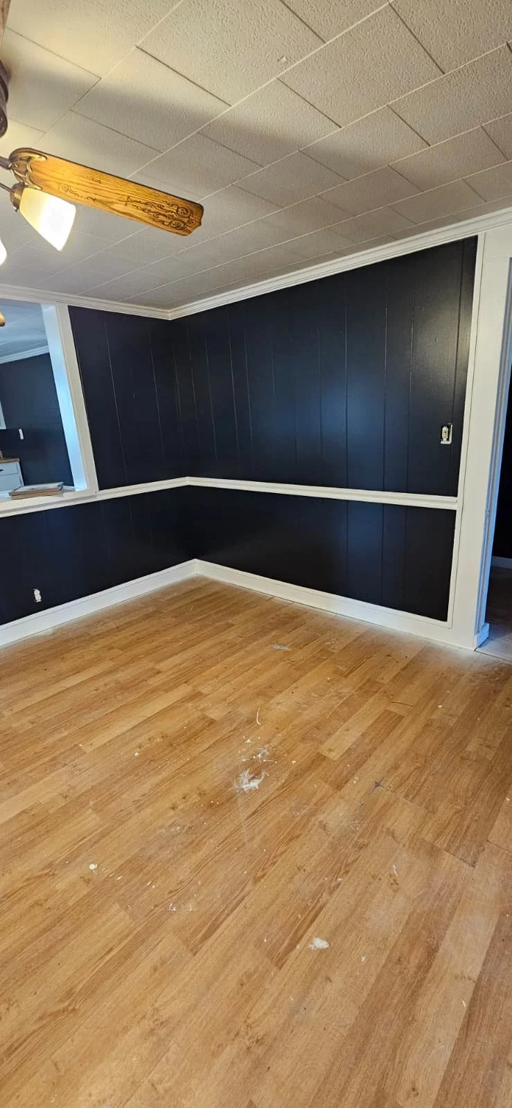 After: An interior painting project in Sardis City, Alabama that entailed painting white wood paneling a high gloss black, with high gloss white trim to contrast the look. This was the dining room area. 