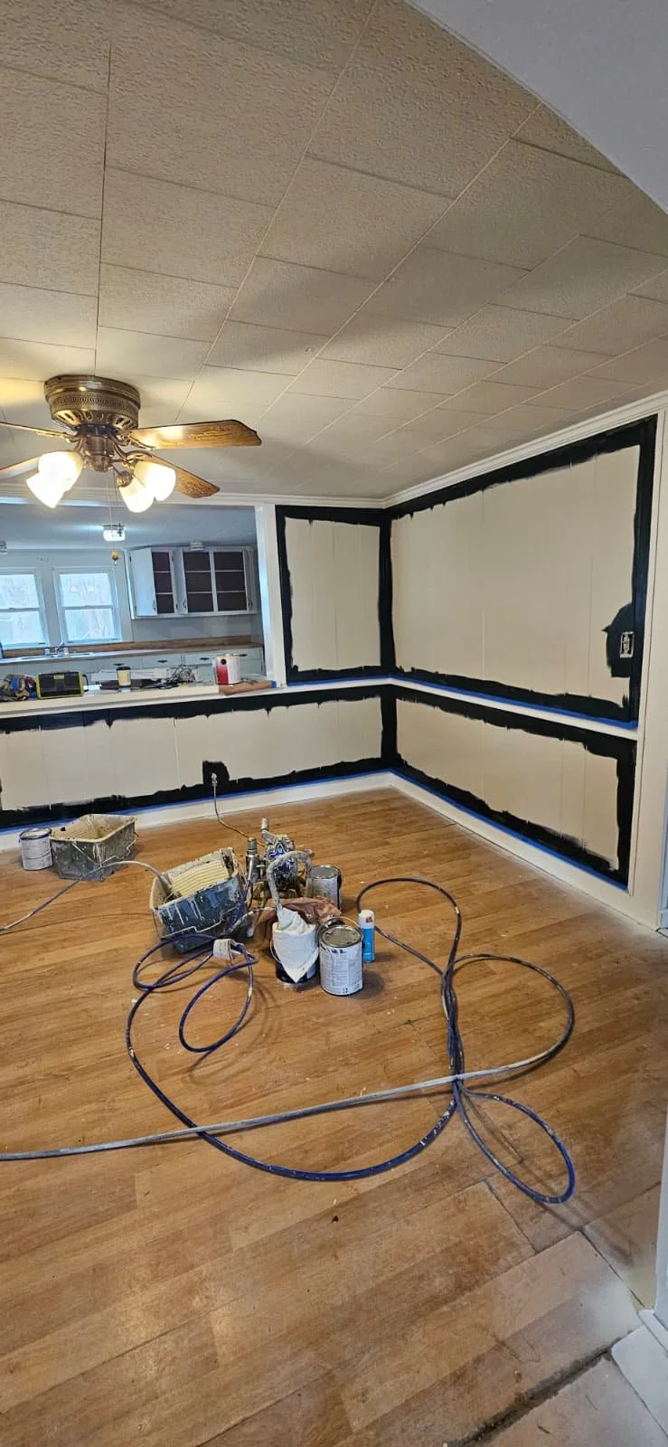 Before: An interior painting project in Sardis City, Alabama that entailed painting white wood paneling a high gloss black, with high gloss white trim to contrast the look. This was the dining room area. 