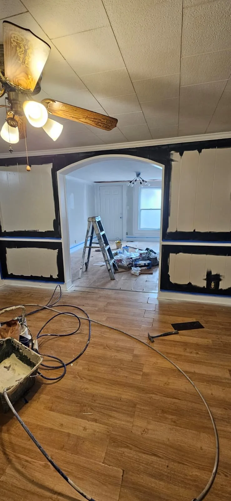 Before: An interior painting project in Sardis City, Alabama that entailed painting white wood paneling a high gloss black, with high gloss white trim to contrast the look. This was the dining room area. 