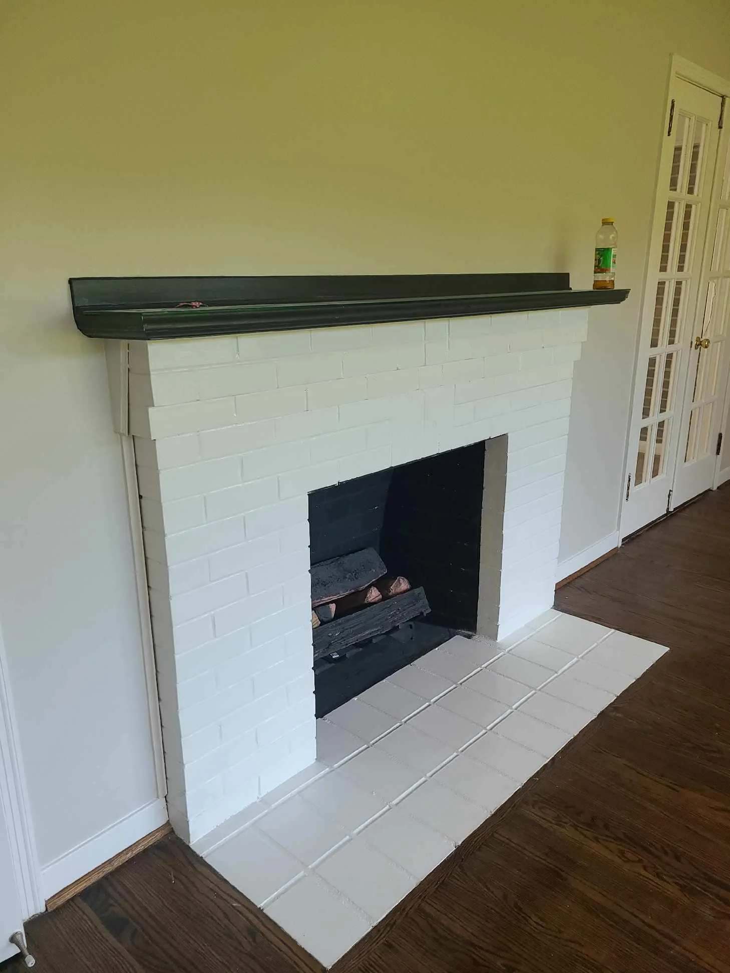 This brick fireplace was painted white to contrast with the black painted mantle in Union Grove, Alabama.