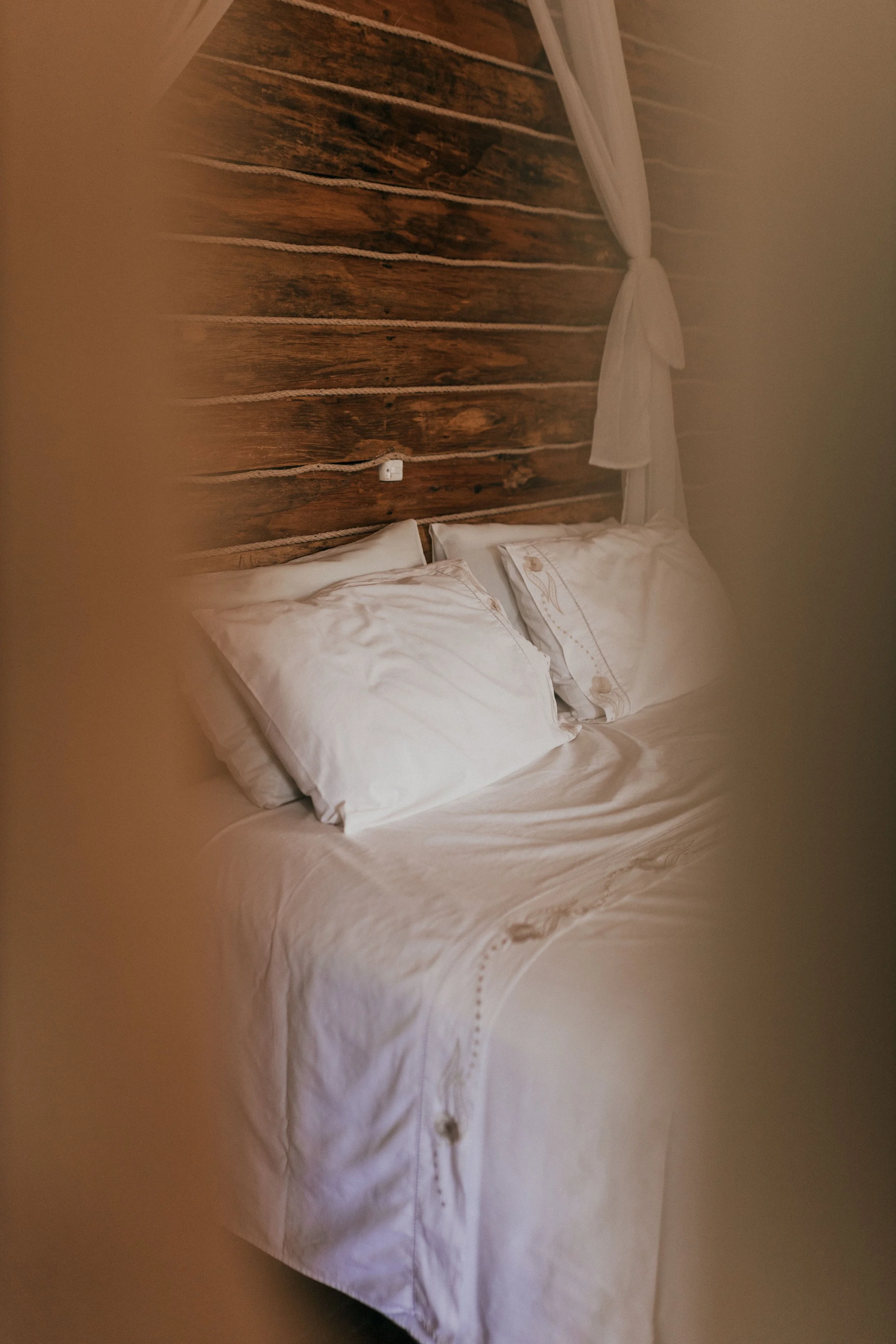 Lit avec des oreillers blancs dans une chambre