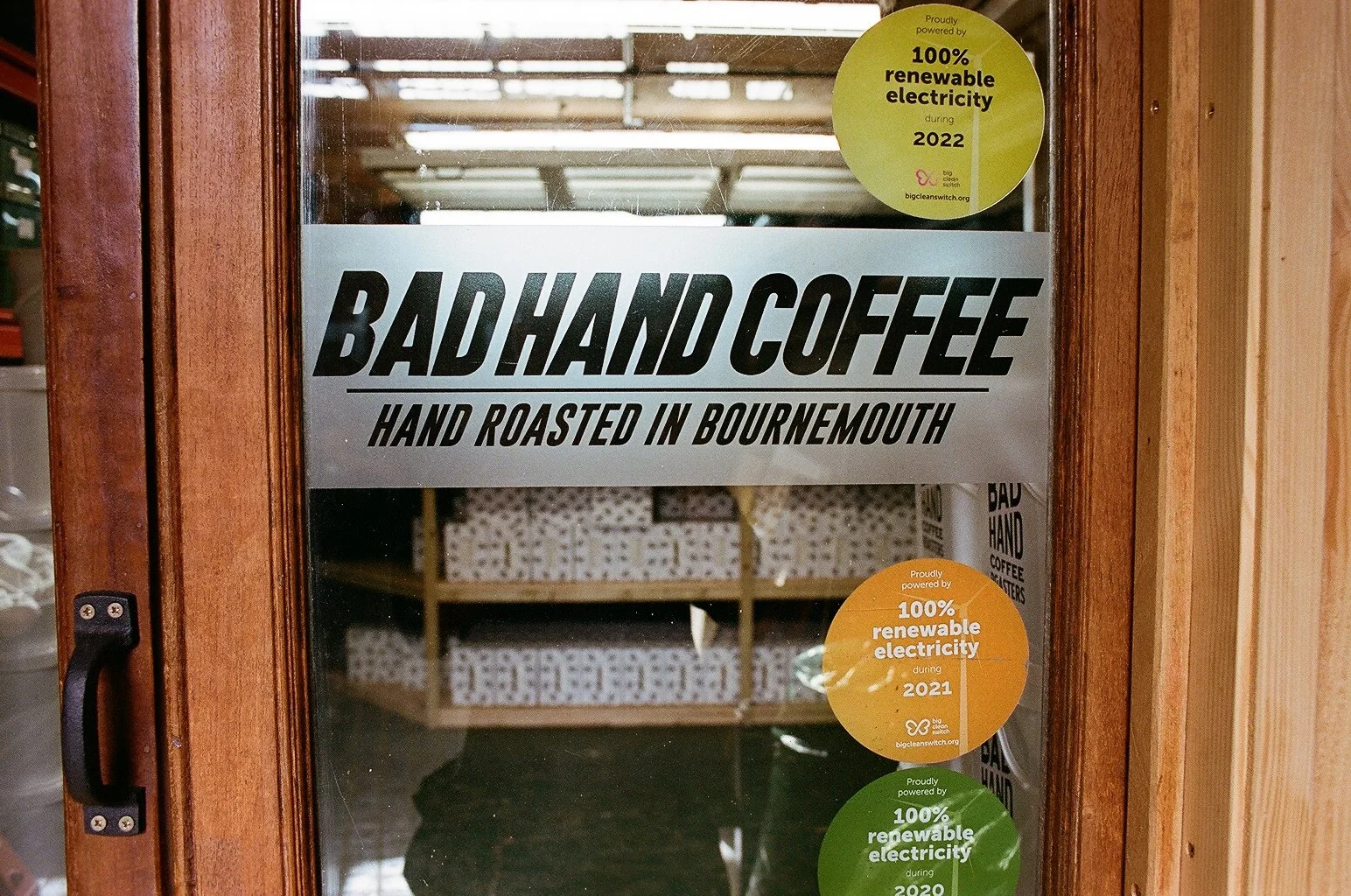 Close-up of the Bad Hand Coffee entrance sign reading hand roasted in Bournemouth. Photo by Shahab Notghi.