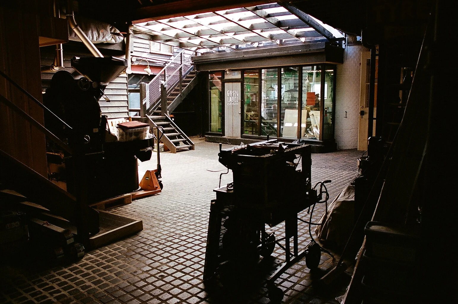 Interior of Green Label Kitchen showing commercial kitchen equipment and the entrance. Photo by Shahab Notghi.