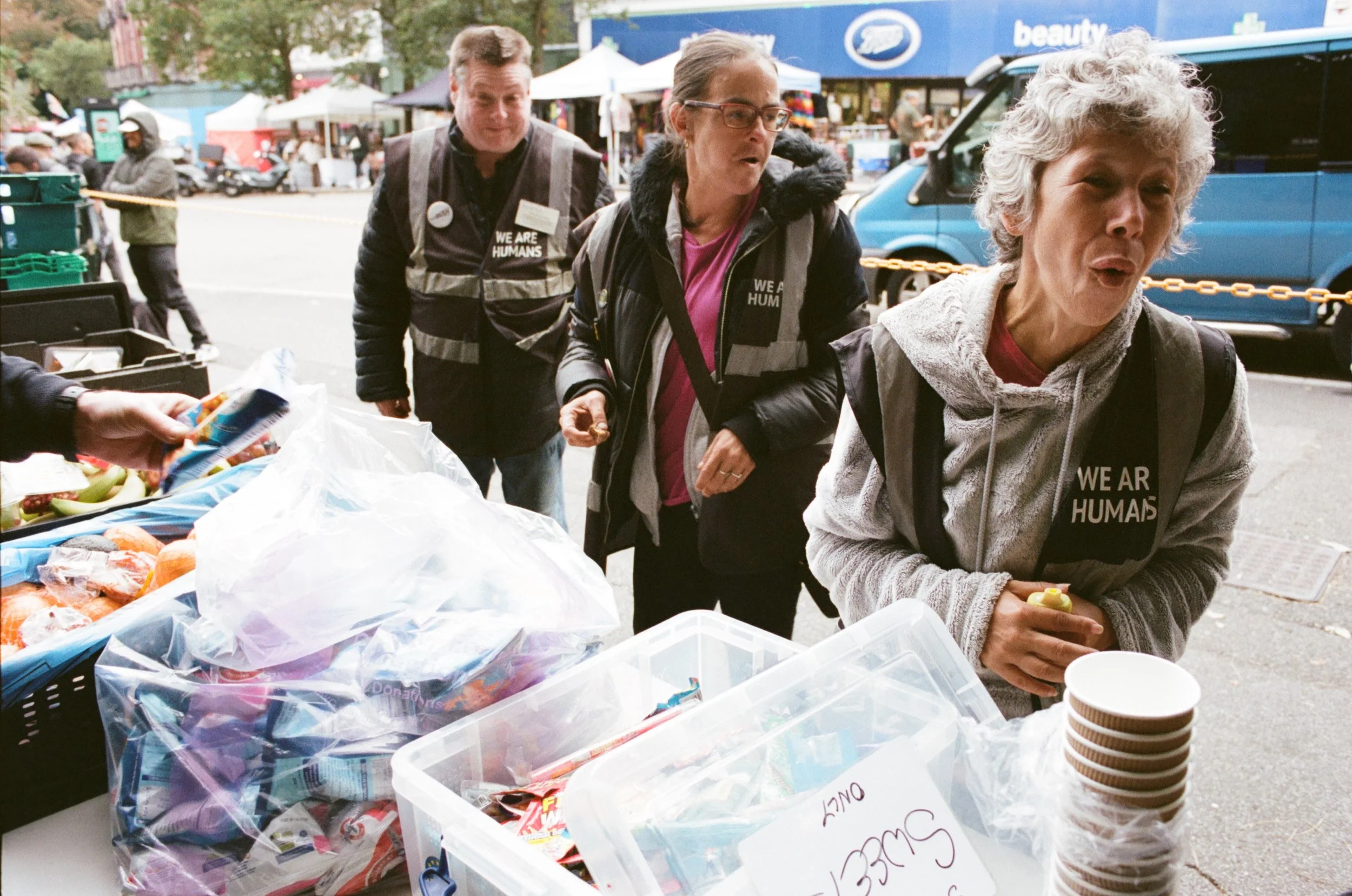 smiling at the We Are Humans charity base in Boscombe, Bournemouth – documentary photography by Shahab Notghi.