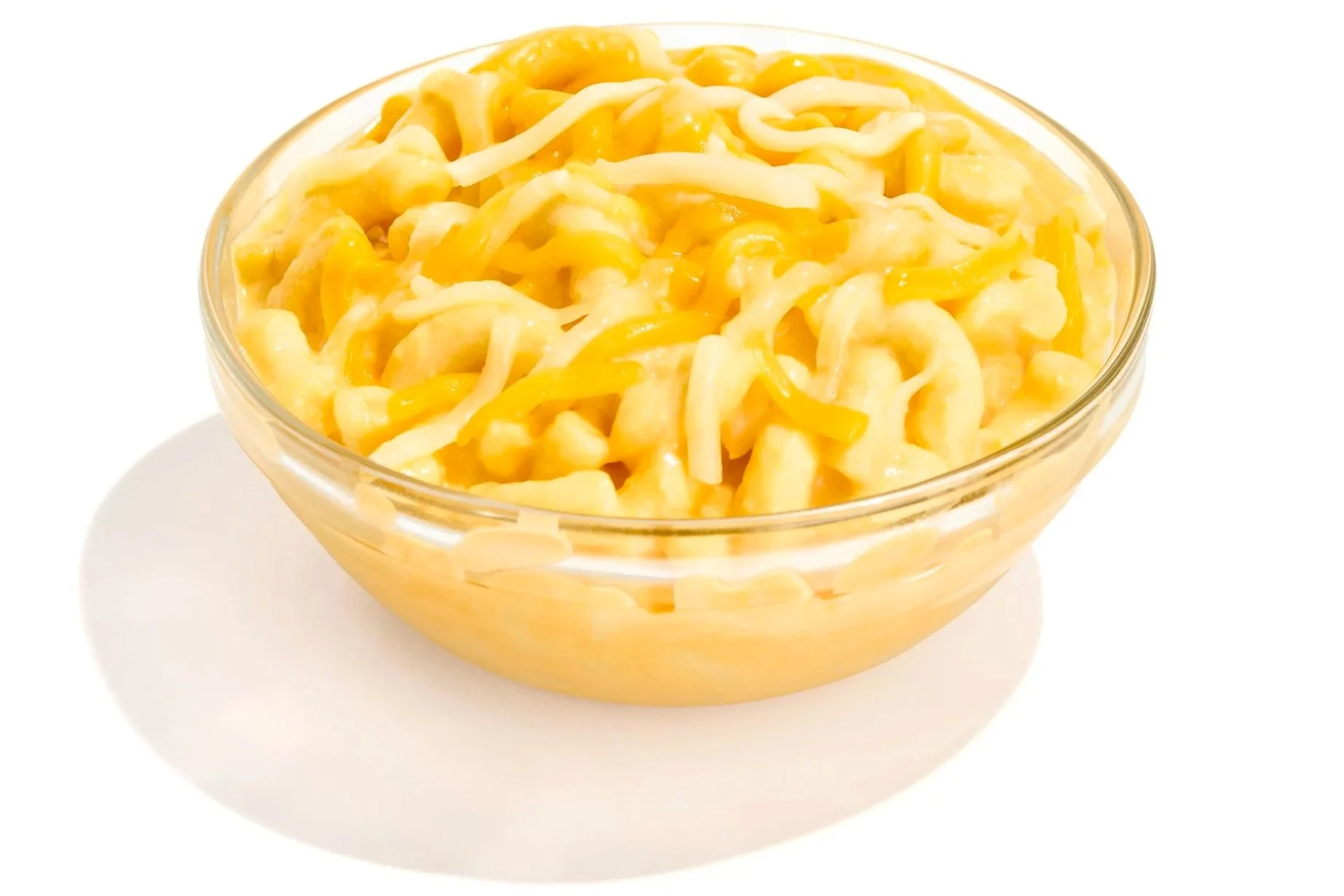 A glass bowl filled with shredded yellow and white cheese.