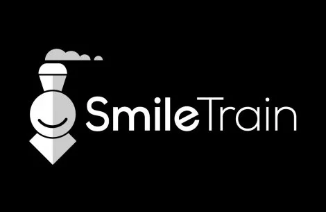 Black and white logo of Smile Train featuring a stylized train with a smiling face next to the text "Smile Train."