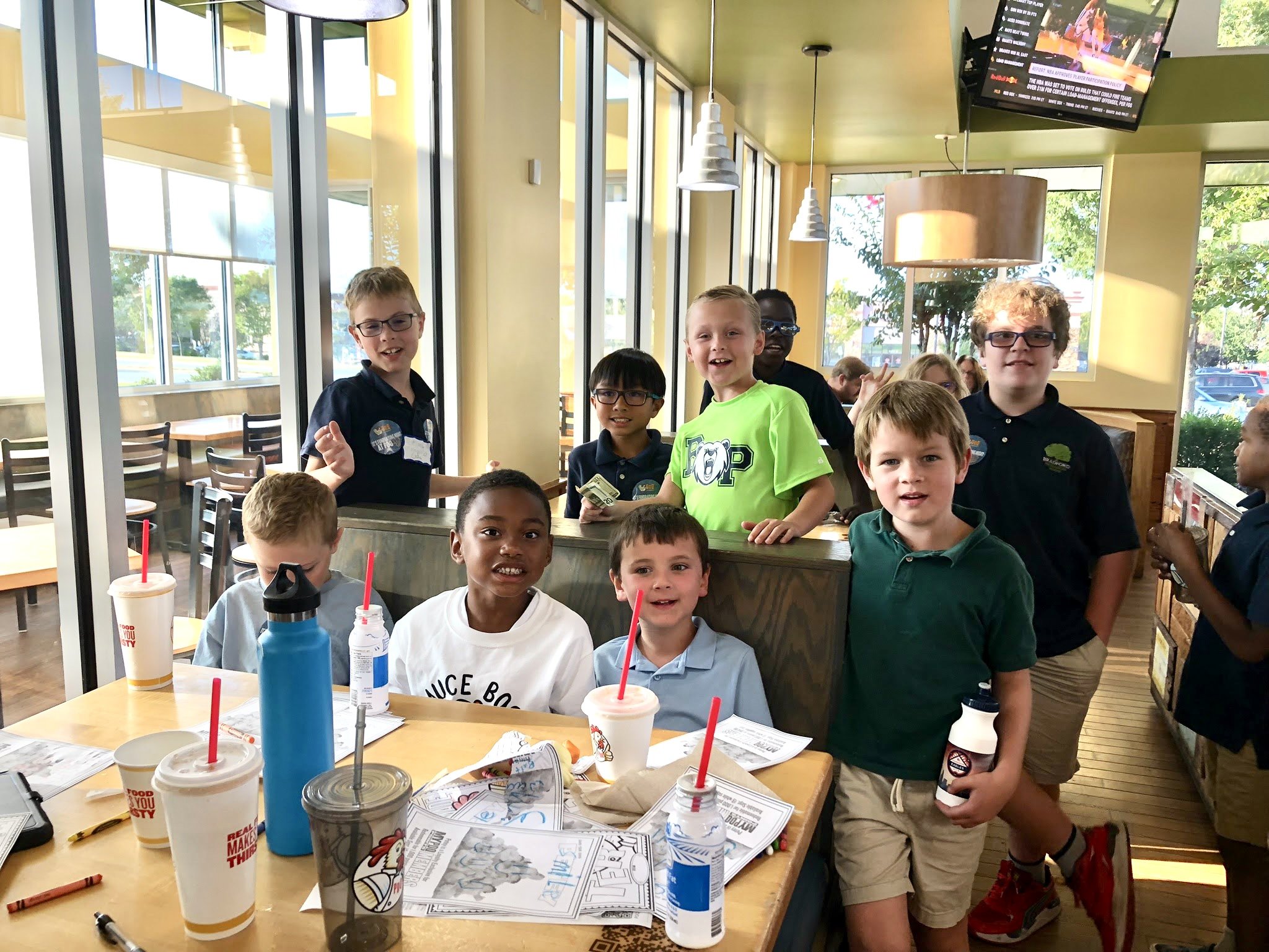 Group of young boys eating and PDQ and smiling for the camera