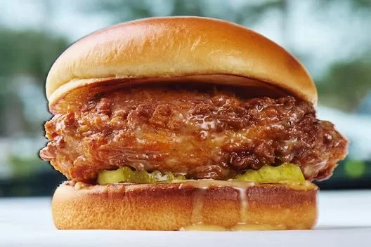 Honey butter glazed chicken breast topped with pickles on a brioche bun