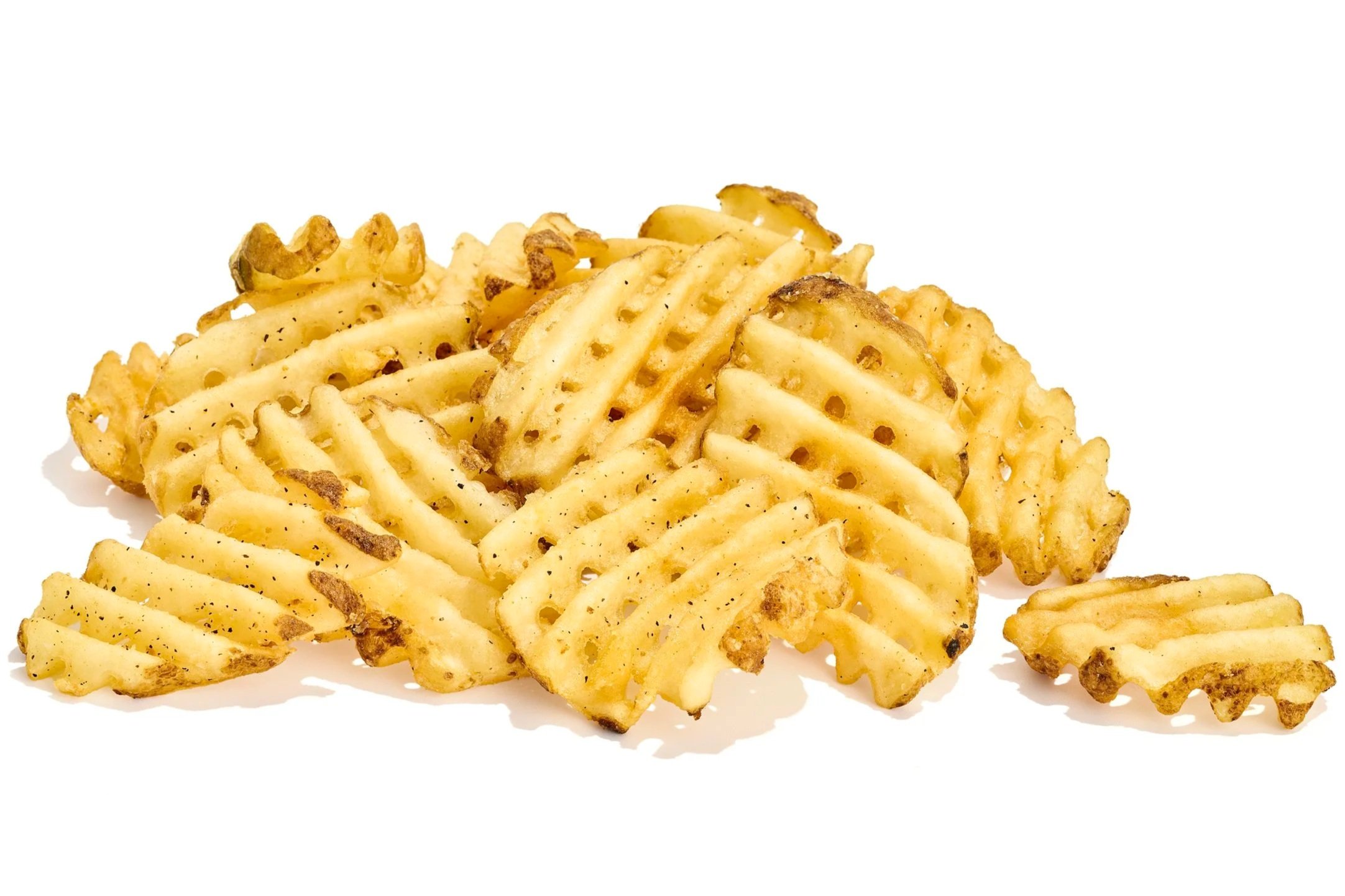Close-up of crispy, golden French fries sprinkled with black pepper on a white background.