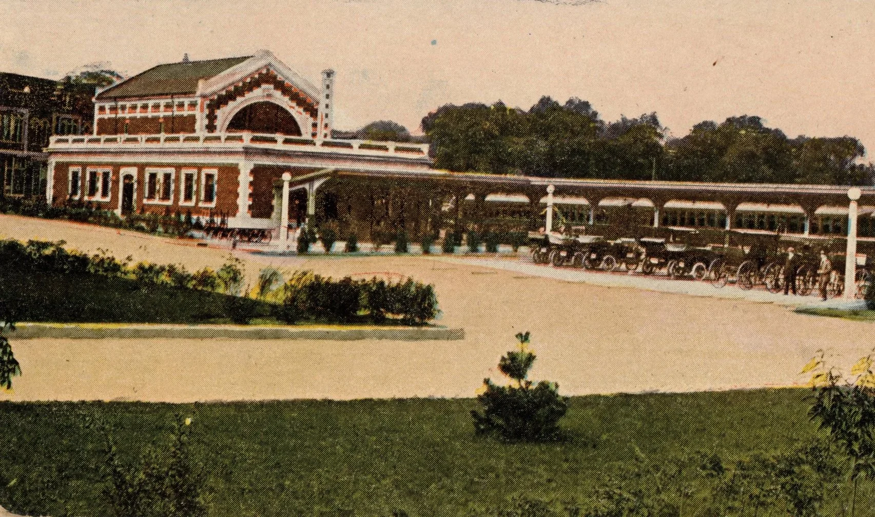 Vintage illustration of a historic train station with a covered platform, multiple trains, and a large building with decorative architecture, surrounded by greenery and trees.