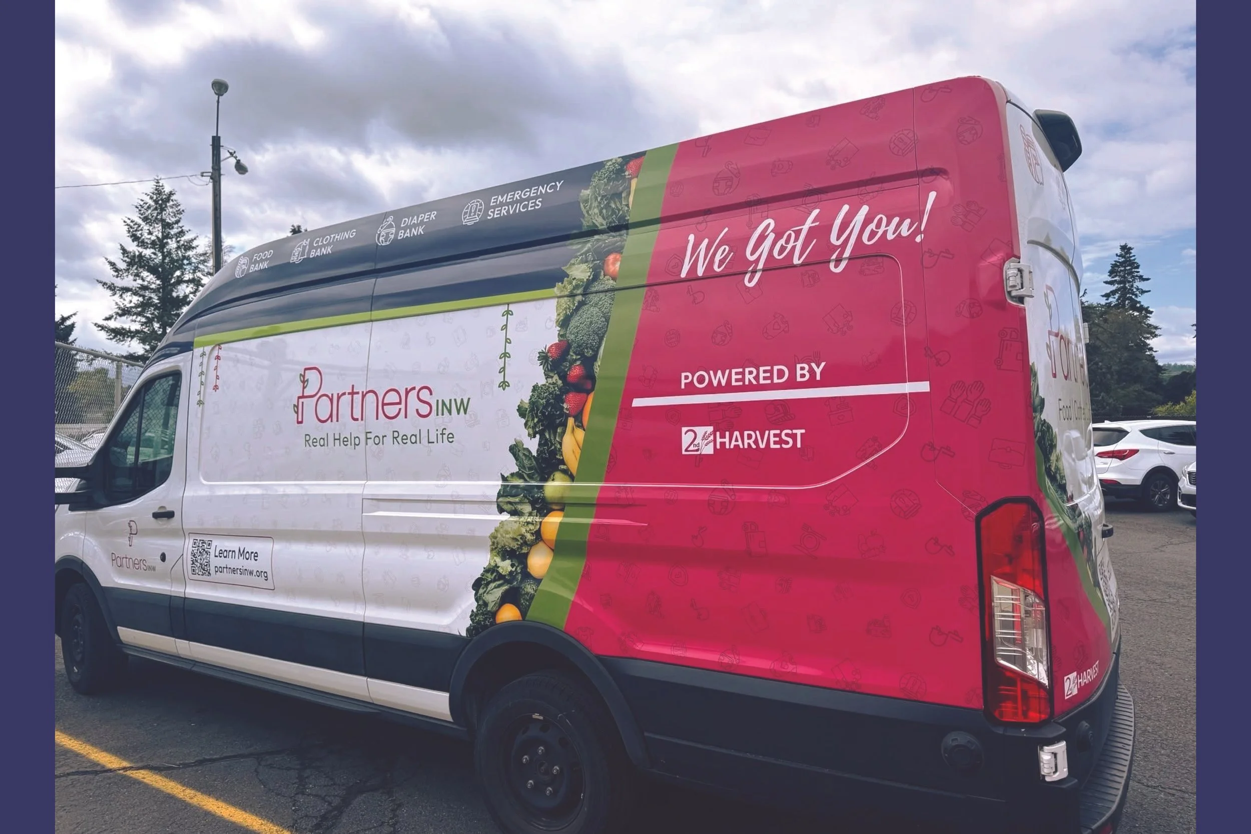 A Partners INW delivery van with colorful graphics and text promoting Partners INW's services, including food bank, clothing bank, diaper bank, and emergency services, with the slogan "We Got You!" and the phrase "Powered by 2nd Harvest."