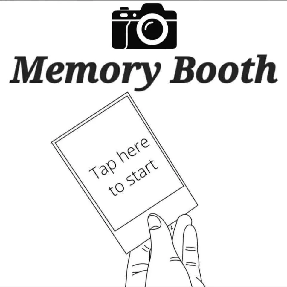 A promotional sign for a memory booth featuring a camera icon, the text 'Memory Booth' in bold, and a finger tapping a touchscreen with the instruction 'Tap here to start'.