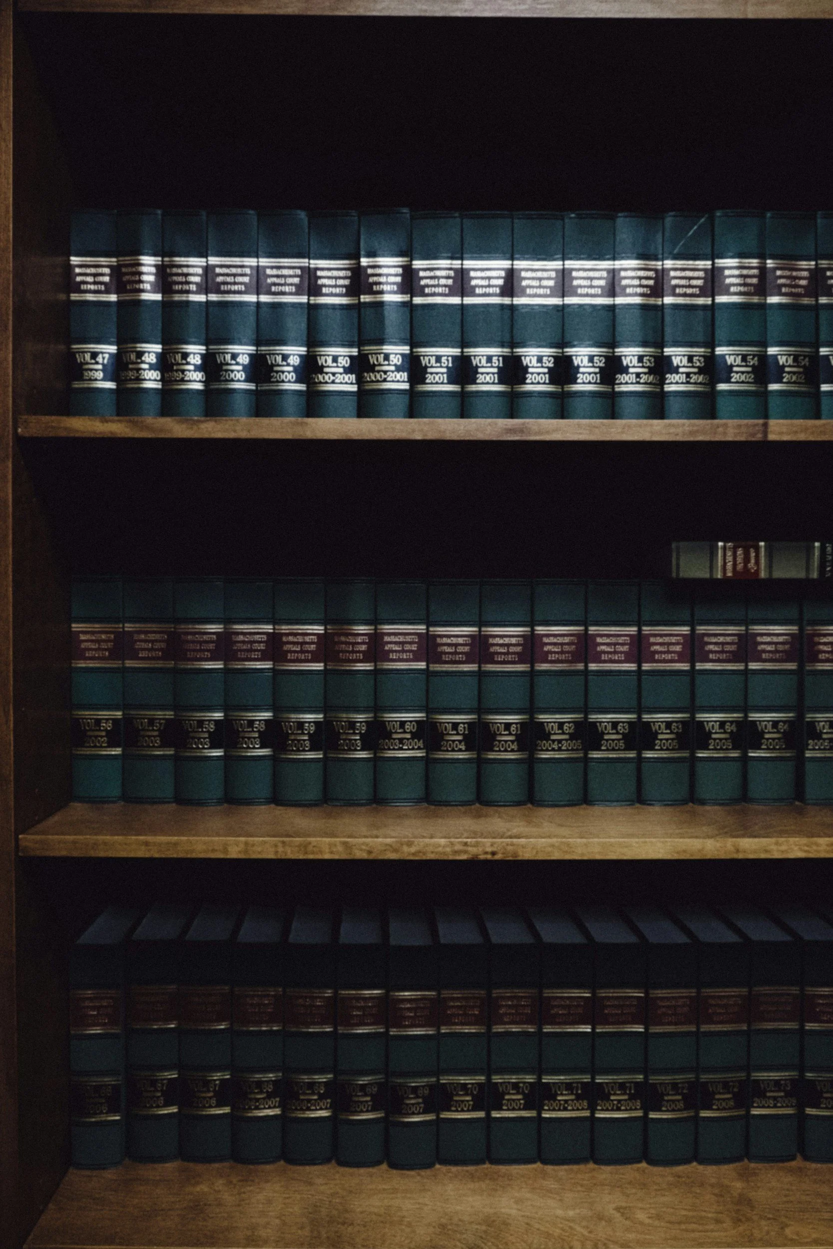 A wooden bookshelf filled with volumes of the 'Narcotics Appellate Court Reports' series, organized by volume and year, with additional volumes on the lower shelves.