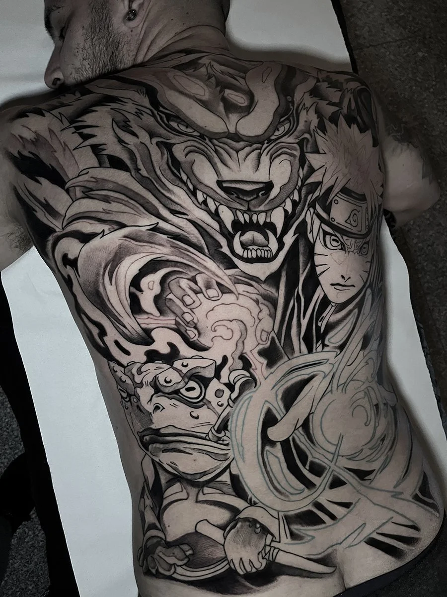 A man with a large detailed black and gray tattoo sleeve covering his chest and arm, featuring a fierce tiger, a ninja character from Naruto, a frog, and swirling patterns. By Johnny Domus, Neo Traditional and Neo Japanese Tattoo.