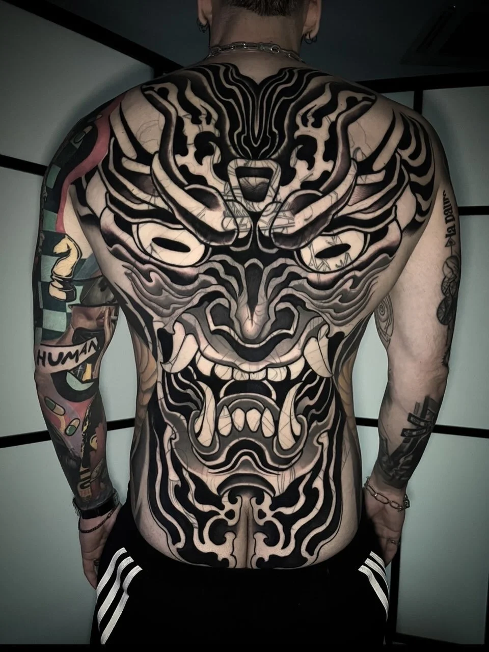 Back tattoo of a fierce warrior face with traditional Japanese style, black and gray ink. By Johnny Domus, Neo Traditional and Neo Japanese Tattoo.