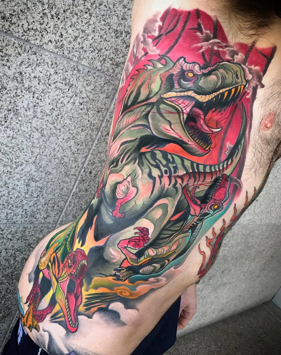 Colorful tattoo of a fierce, roaring dragon with sharp teeth and a serpent-like body, covering the person's side and extending to the back. By Johnny Domus, Neo Traditional and Neo Japanese Tattoo.