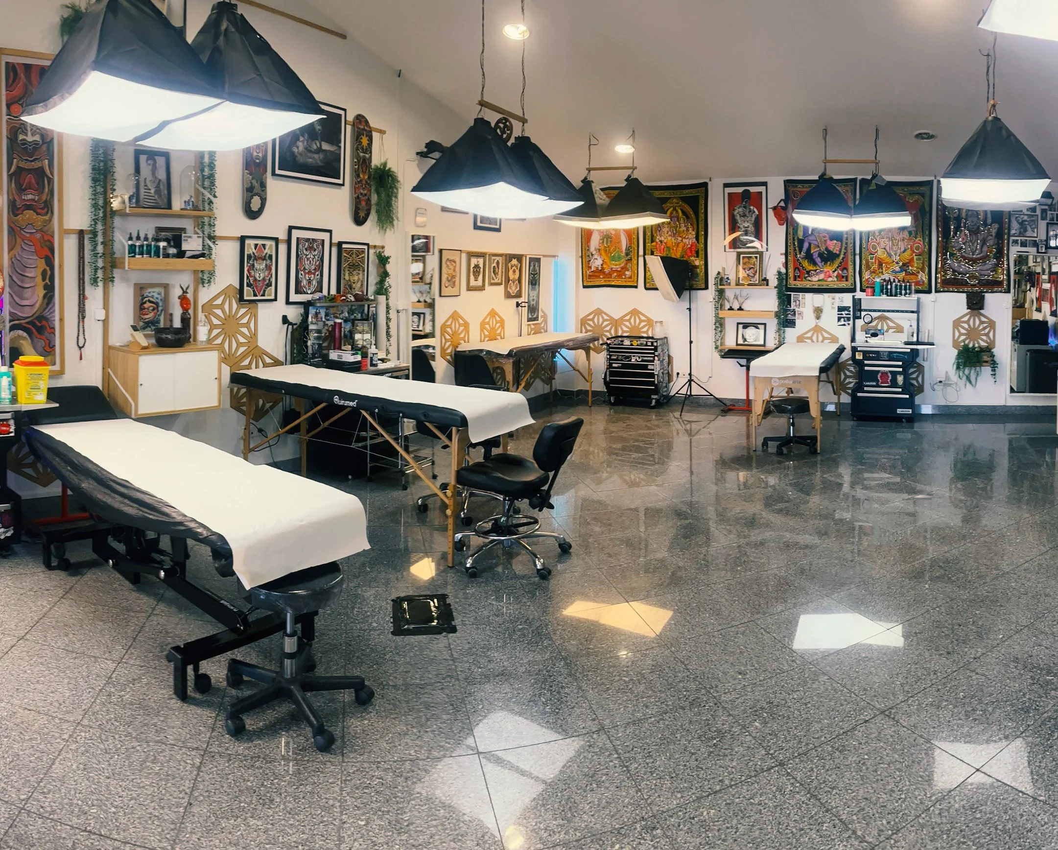 Tattoo shop with tattooing tables, tattoo designs on the walls, tattoo equipment, and adjustable chairs. By Johnny Domus, Neo Traditional and Neo Japanese Tattoo.