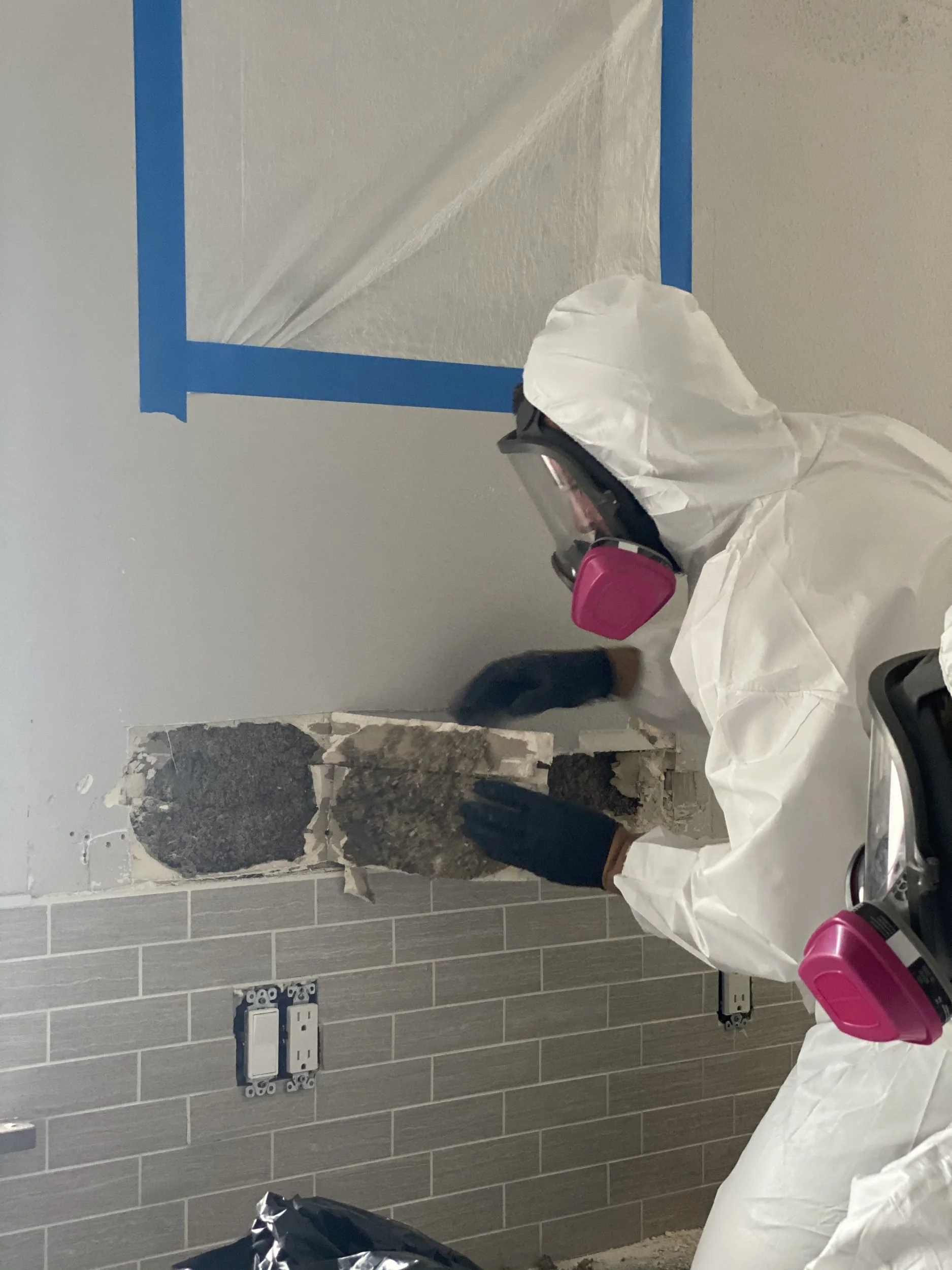 OTM technician in full protective gear removing mold-damaged material