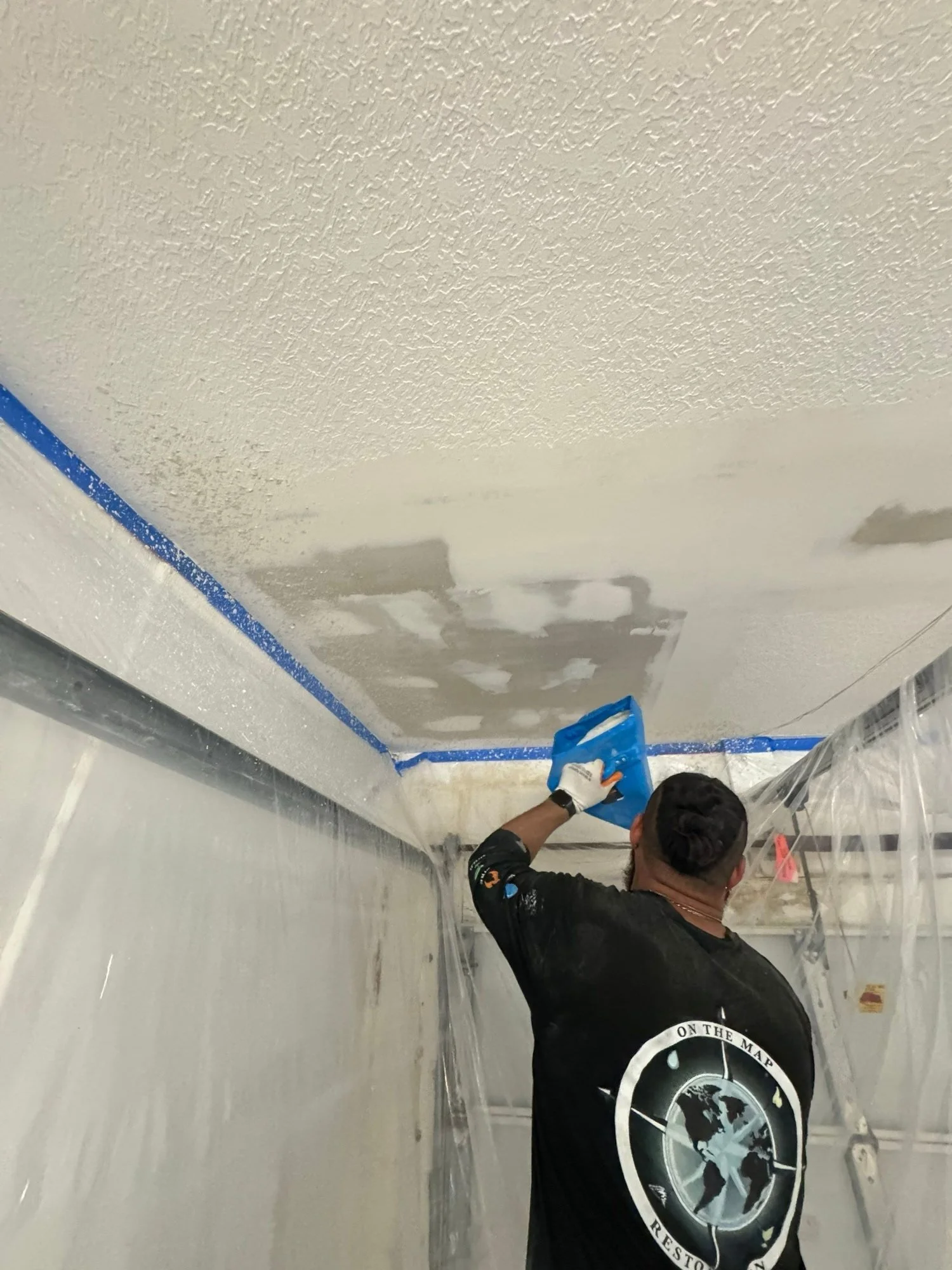OTM technician matching ceiling texture after water damage repairs