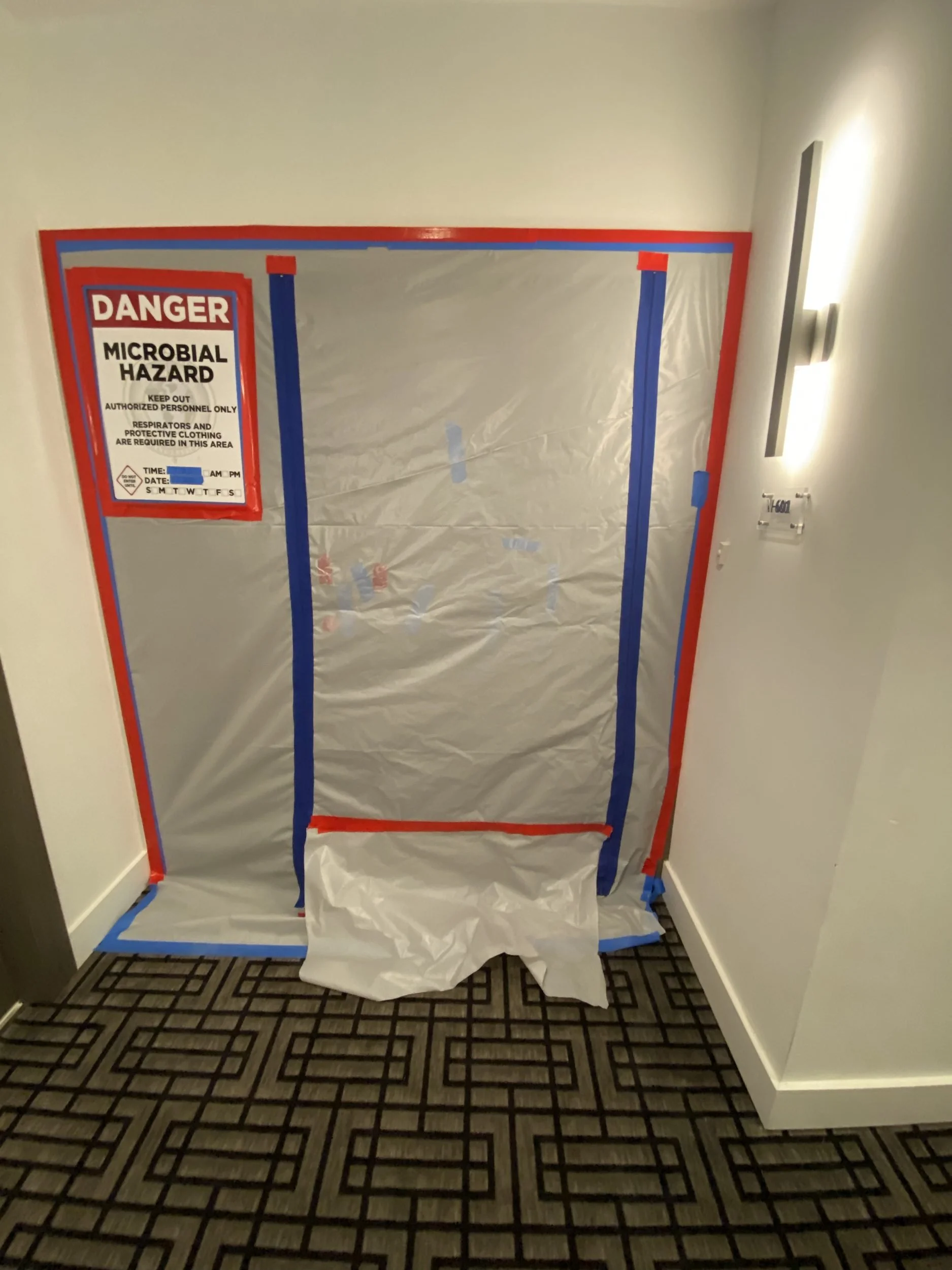 Mold remediation containment barrier with a microbial hazard warning sign