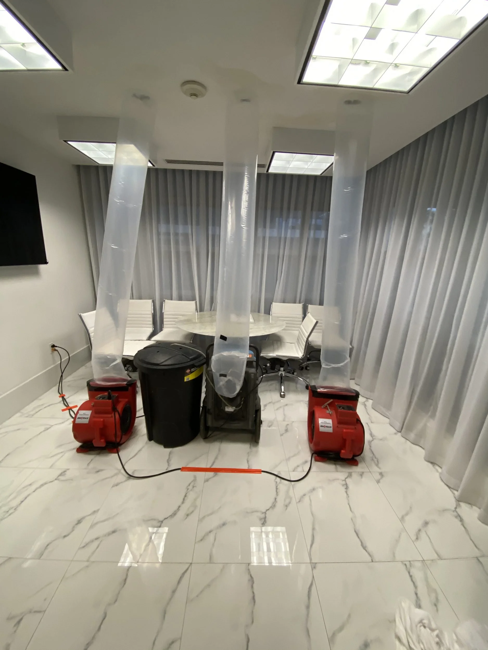 Air movers, dehumidifier and air scrubber drying a water-damaged room