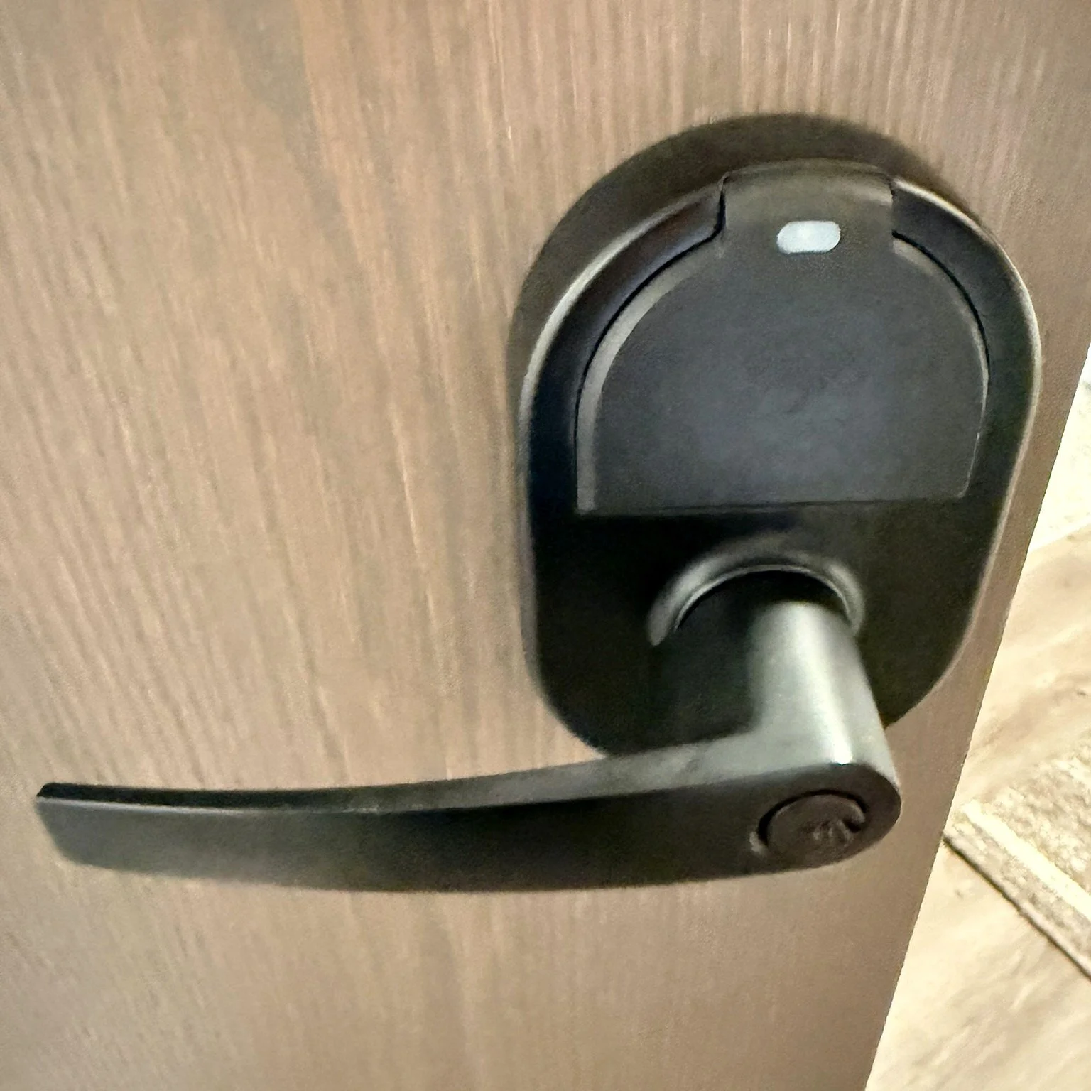 Close-up of a black Grade 1 keyless lever lock installed by ZeroKey on an apartment door