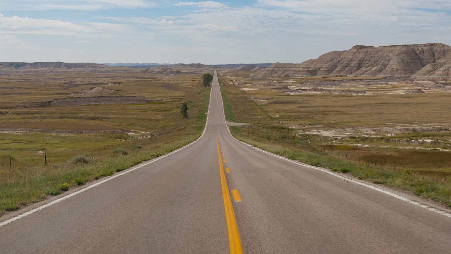A long, empty two-lane road stretching across the South Dakota prairie.