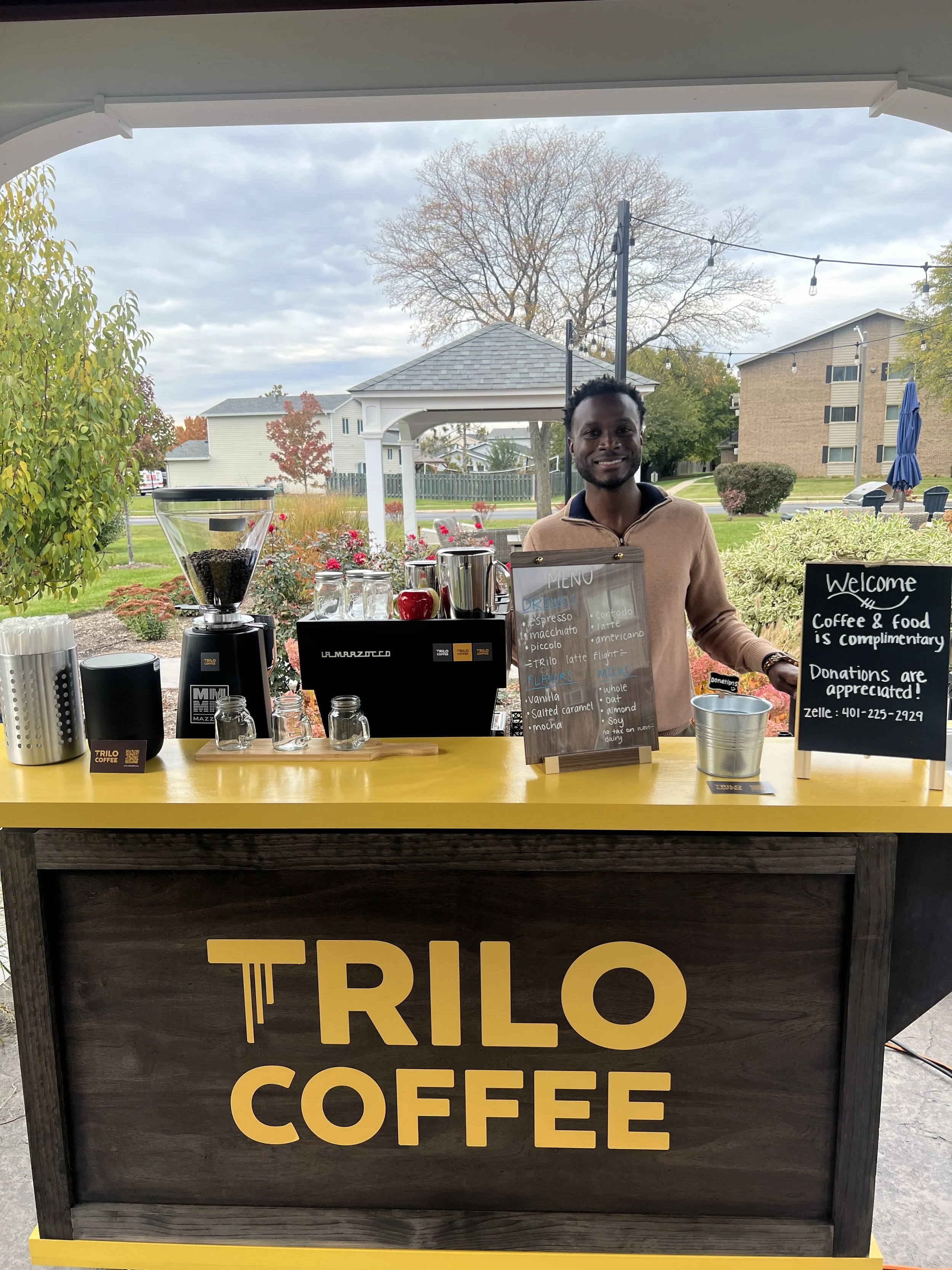 Keanu Taylor standing behind the Trilo Coffee cart.