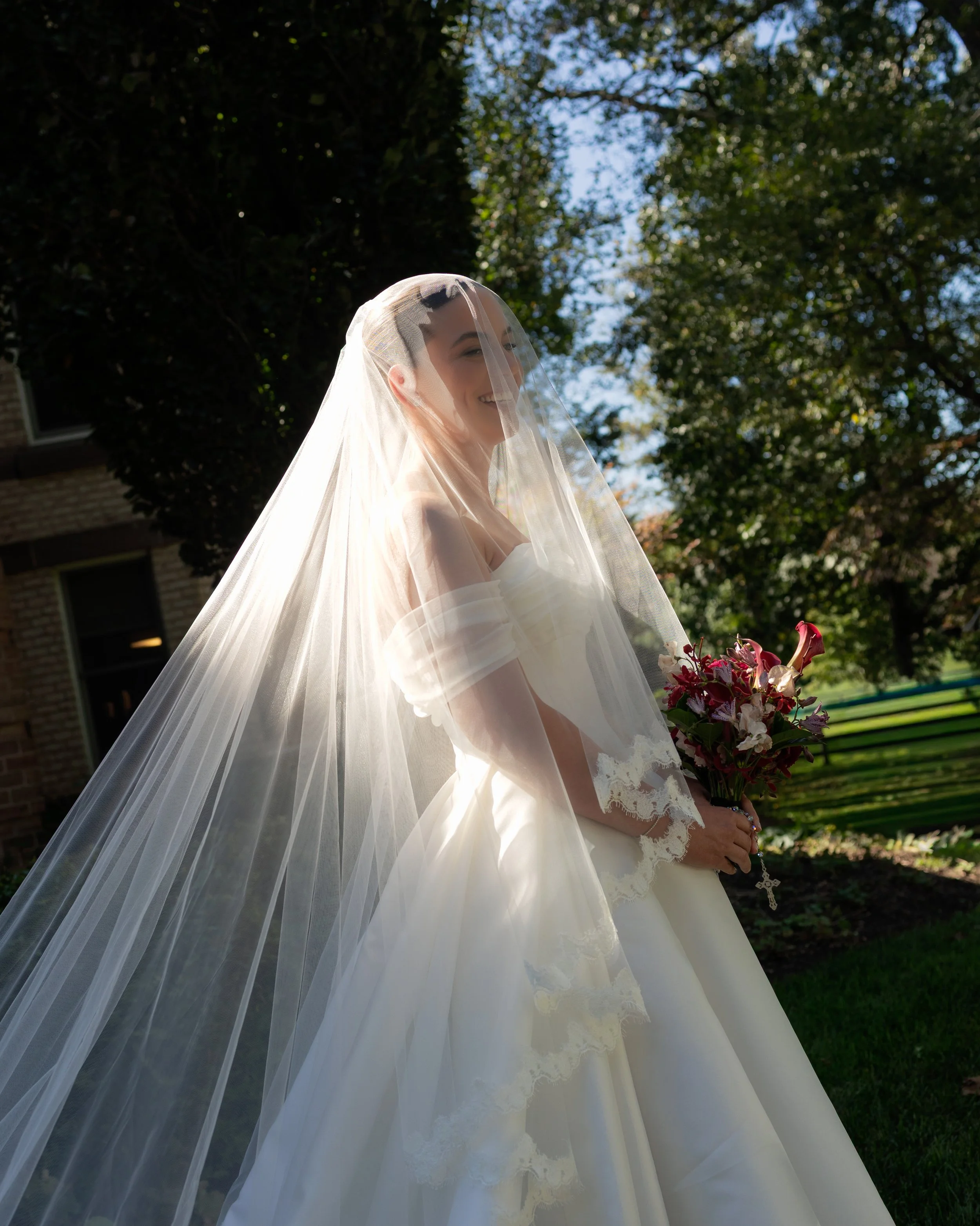 Laurie’s customers, Mariana and Carmen holding hands on a green lawn on their wedding day.