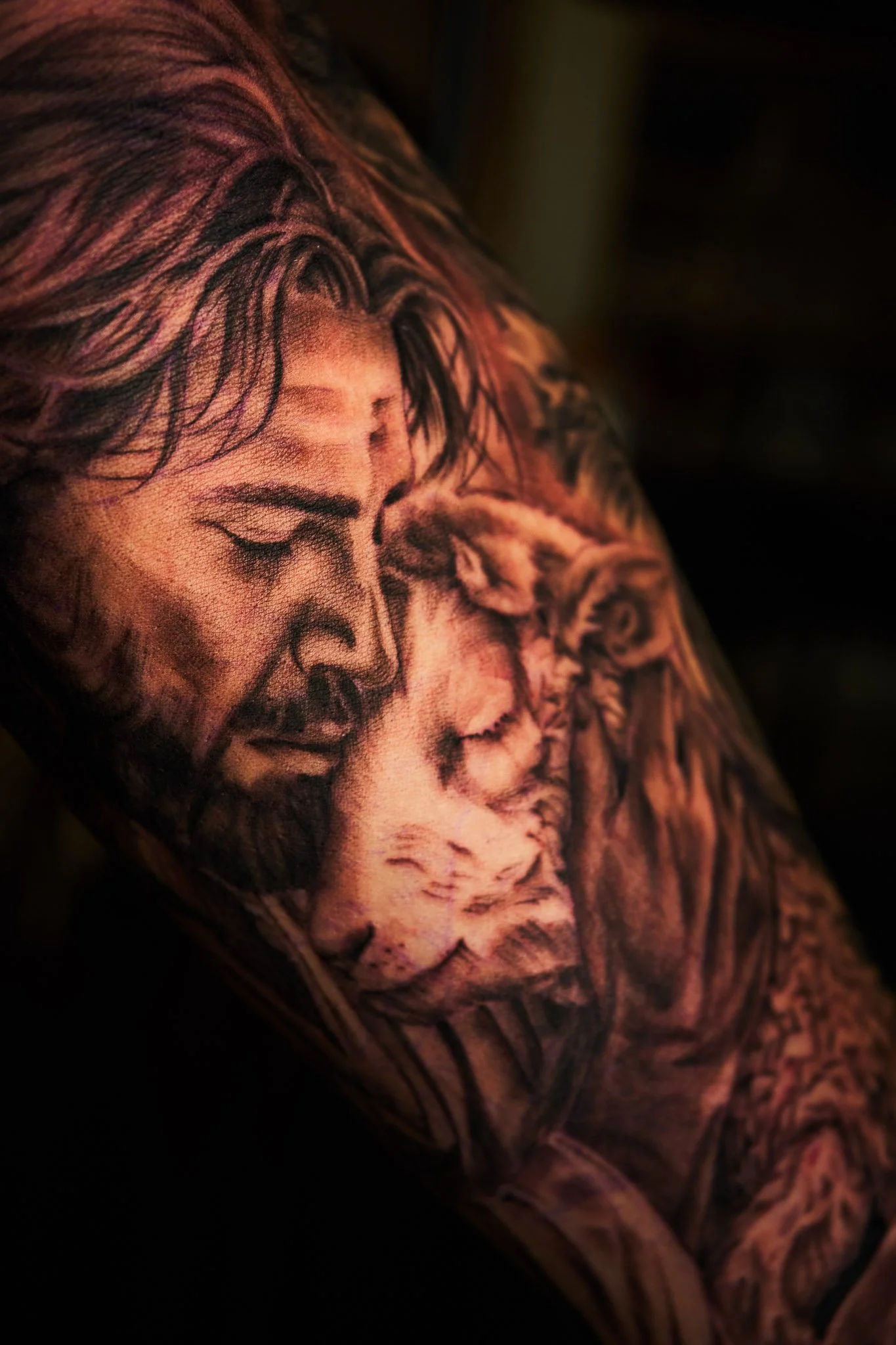 Close-up of a detailed black and gray tattoo of Jesus and sheep.