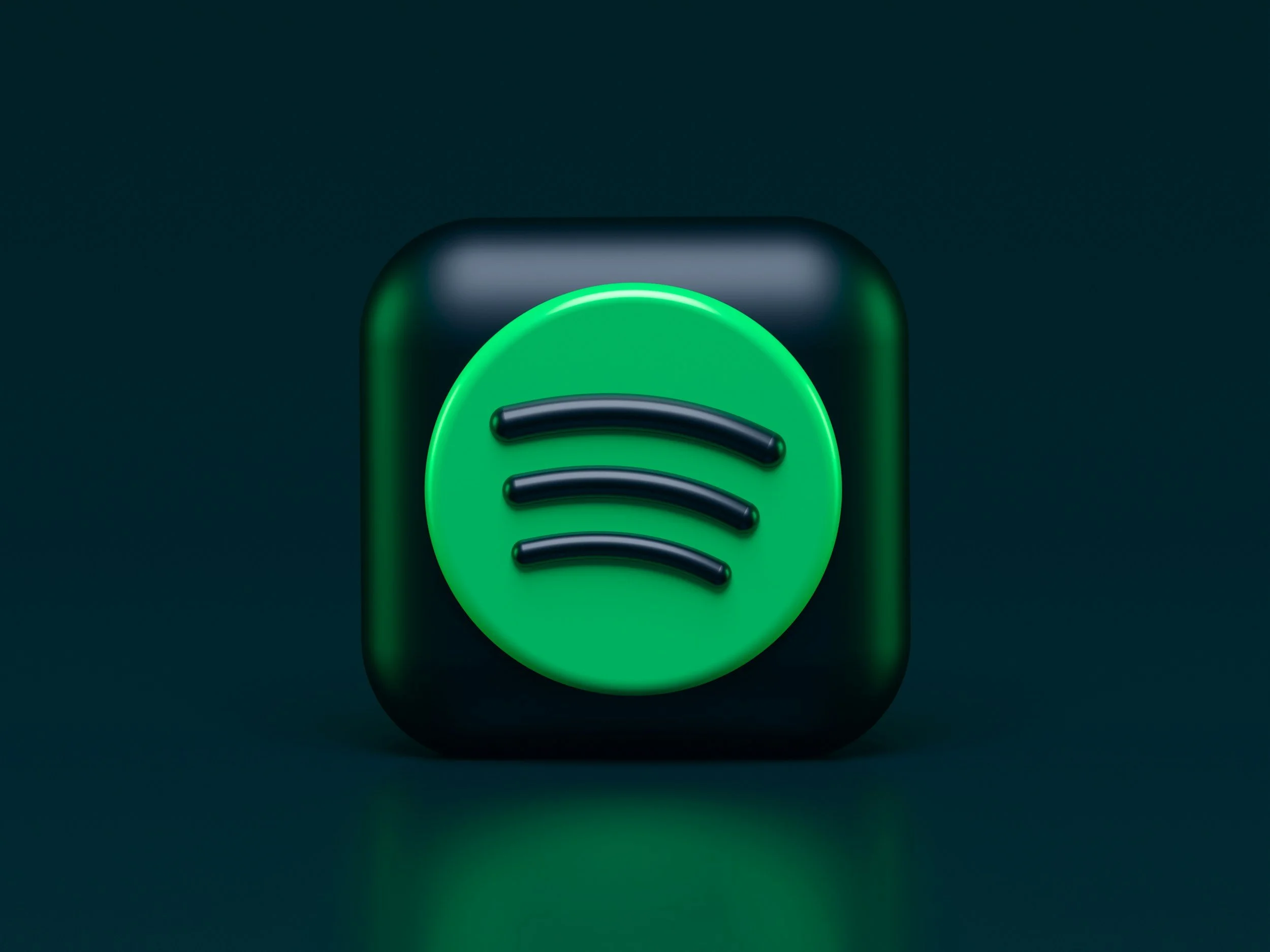 Close-up of a dark-colored device with a glowing green circular element and a black curved line design, set against a dark background.