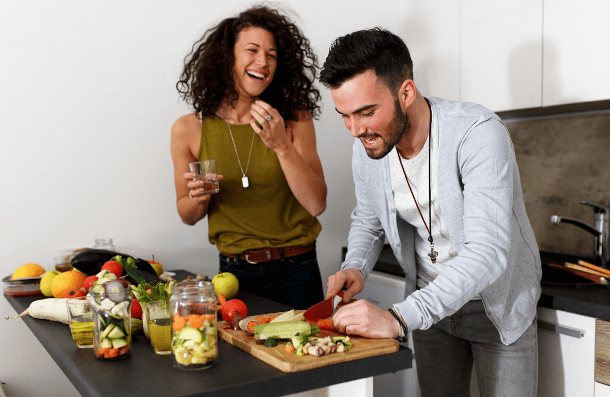 A man and woman preparing or eating a healthy, nutritious meal together in a bright kitchen, representing Fit with Lisa nutrition coaching.