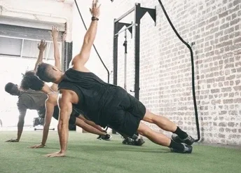 A group of people performing side plank exercises during small group workout with Fit with Lisa