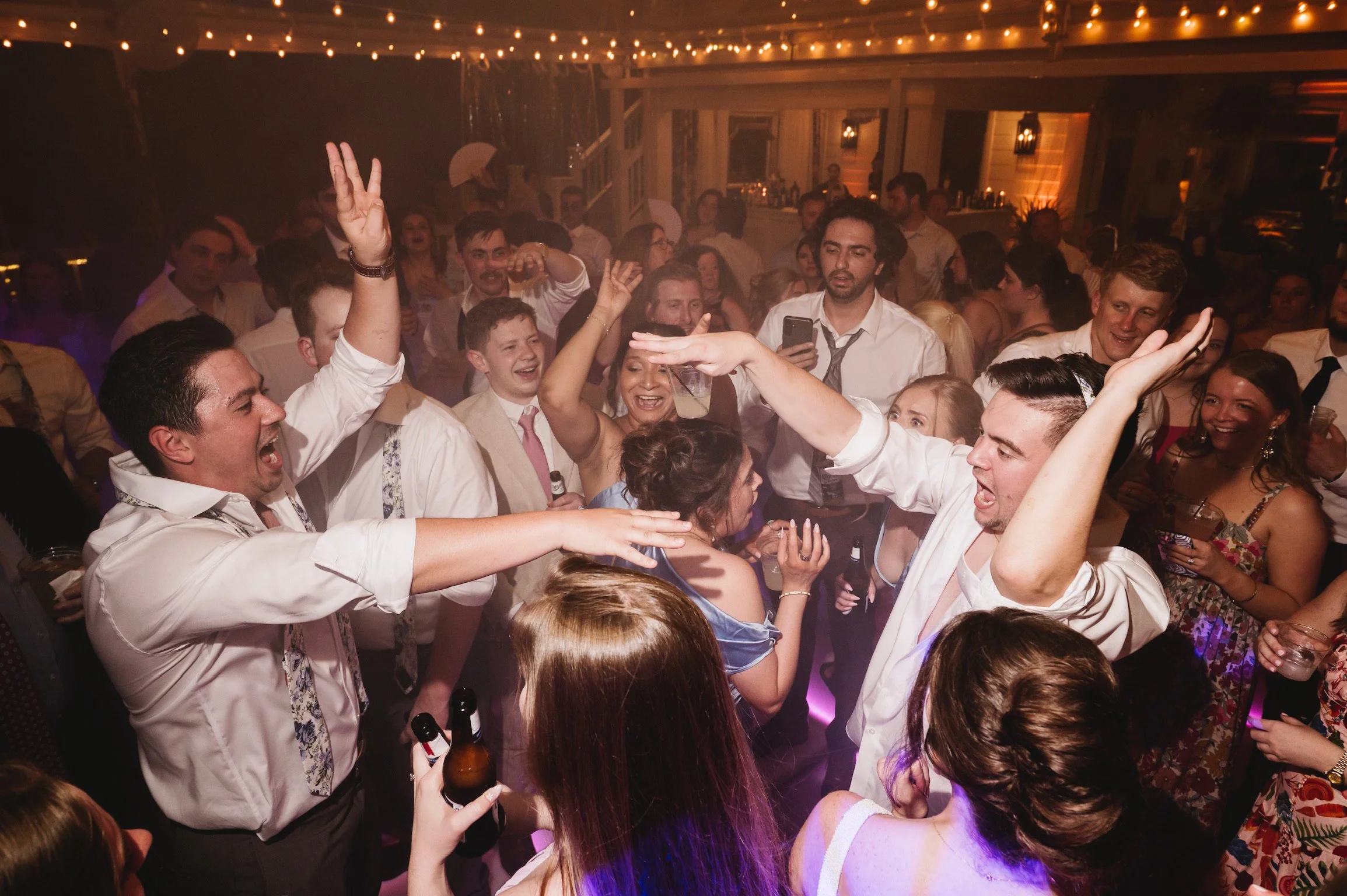 Wedding guests dancing together during a high energy reception