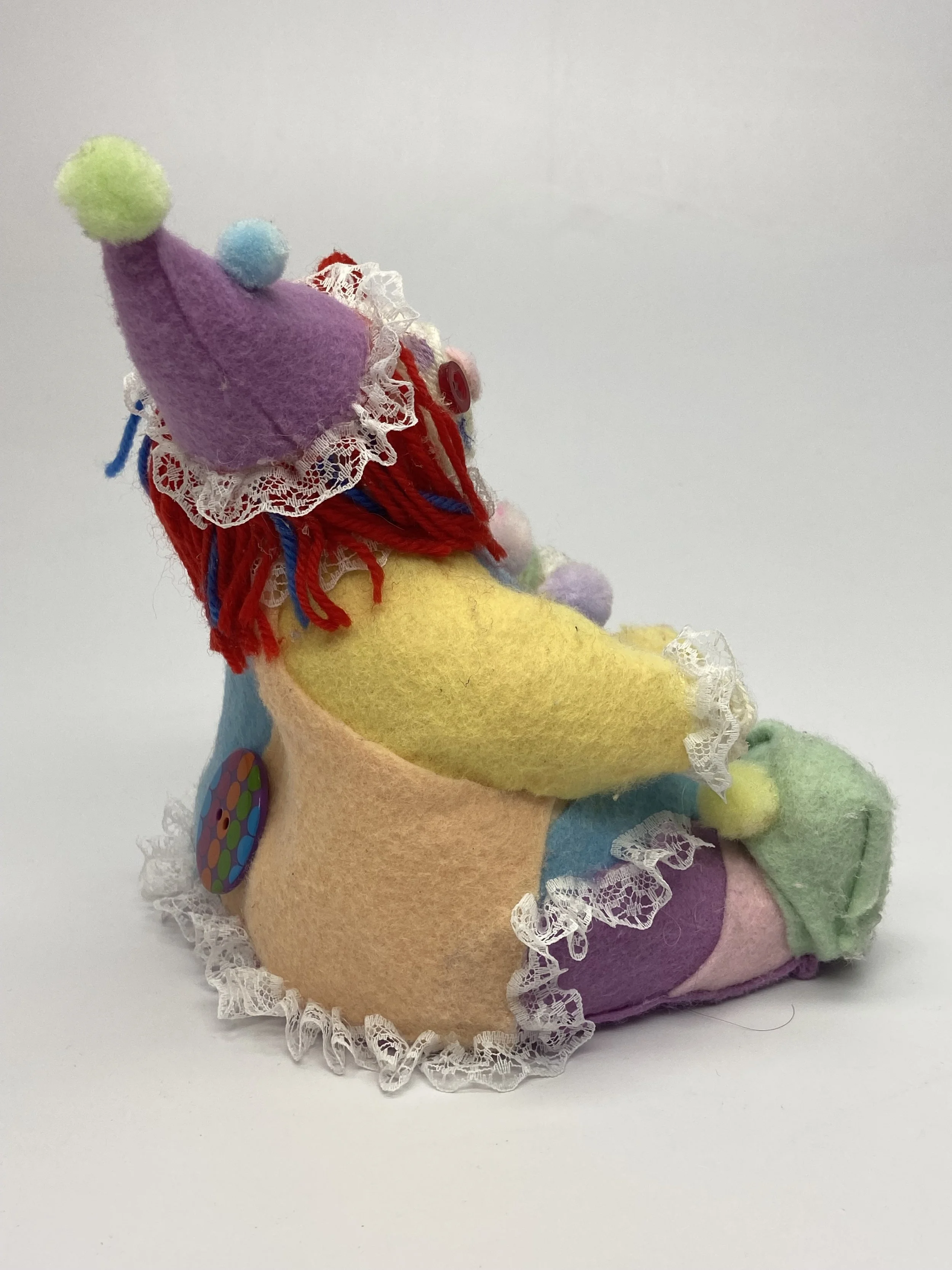 Silly Jo (back), ceramic core with yarn, felt, pompoms, and lace, 2024