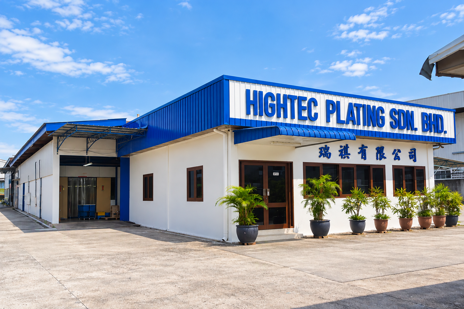 A white building with blue signage that reads "HIGHTEC PLATING SDN. BHD." and Chinese characters, with potted plants outside and a clear blue sky overhead.